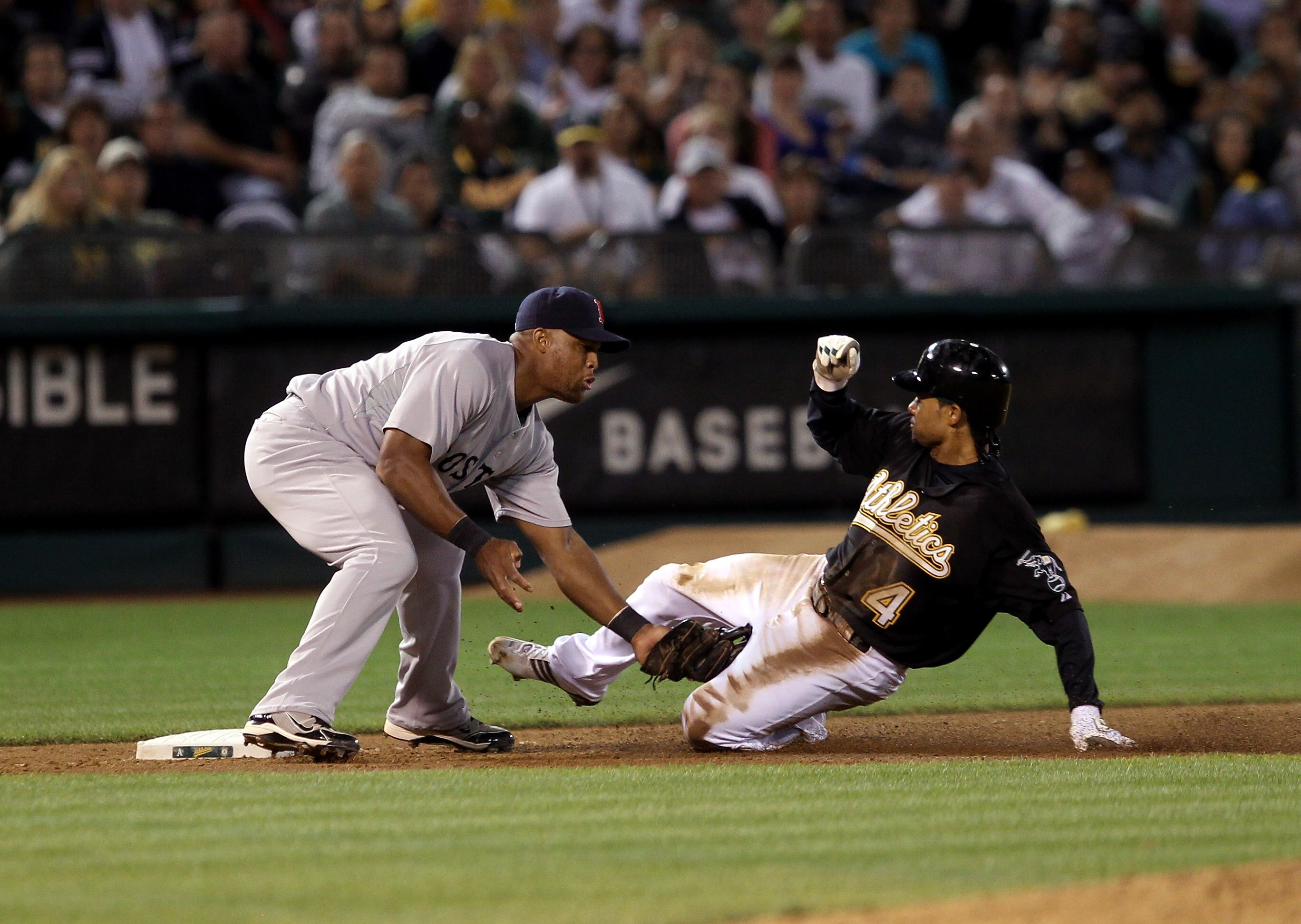 OAKLAND, CA - SEPTEMBER 10:  Coco Crisp #4 of the Oakland Athletics is tagged out by Adrian Beltre #29 of the Boston Red Sox after Crisp tried to reach third base after tagging up on a fly out to center field at the Oakland-Alameda County Coliseum on Sept