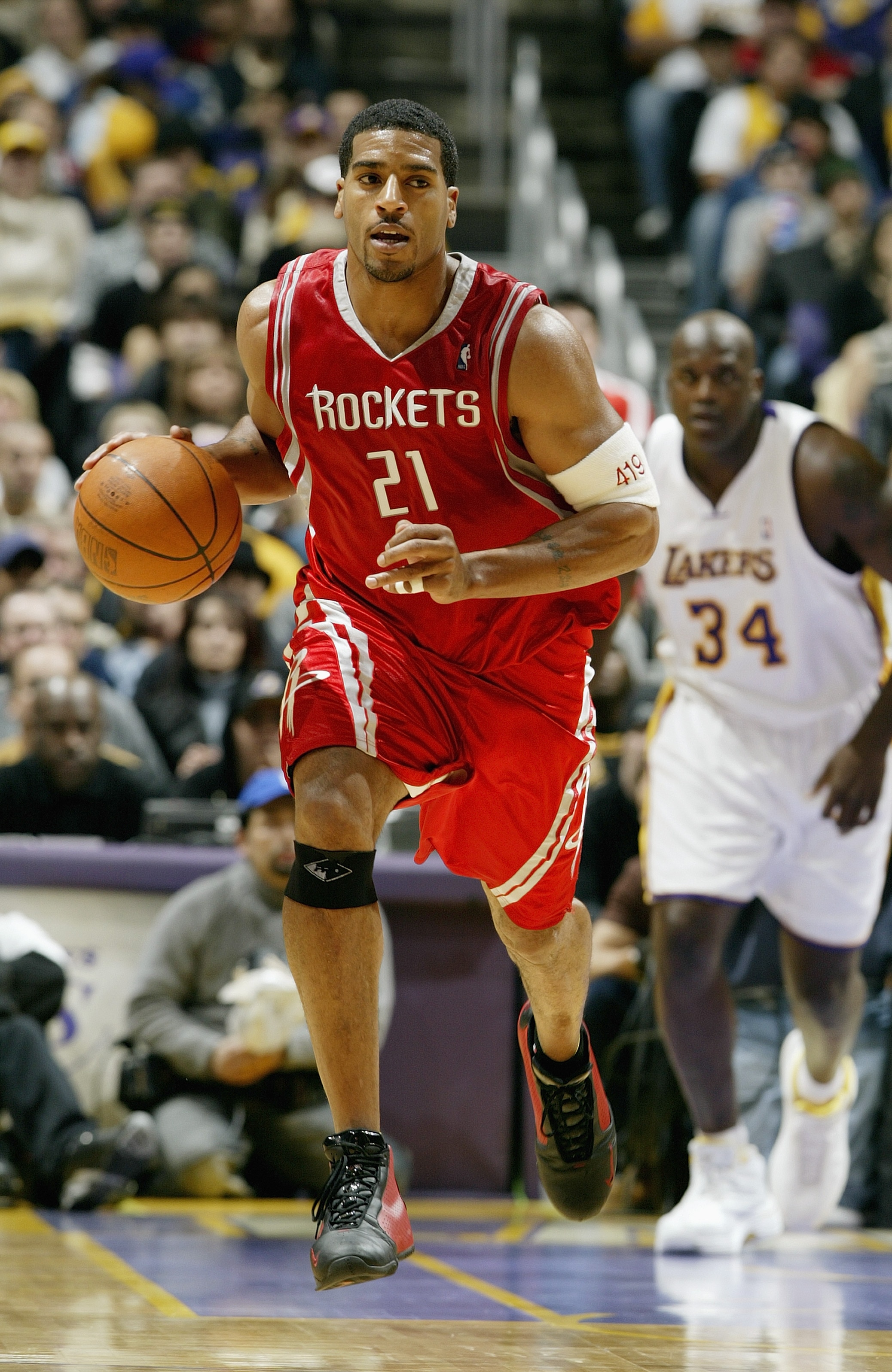 LOS ANGELES - DECEMBER 25:  Jim Jackson #21 of the Houston Rockets moves the ball up court during the game against the Los Angeles Lakers on December 25, 2003 at the Staples Center in Los Angeles, California.  The Rockets won 99-87.  NOTE TO USER: User ex