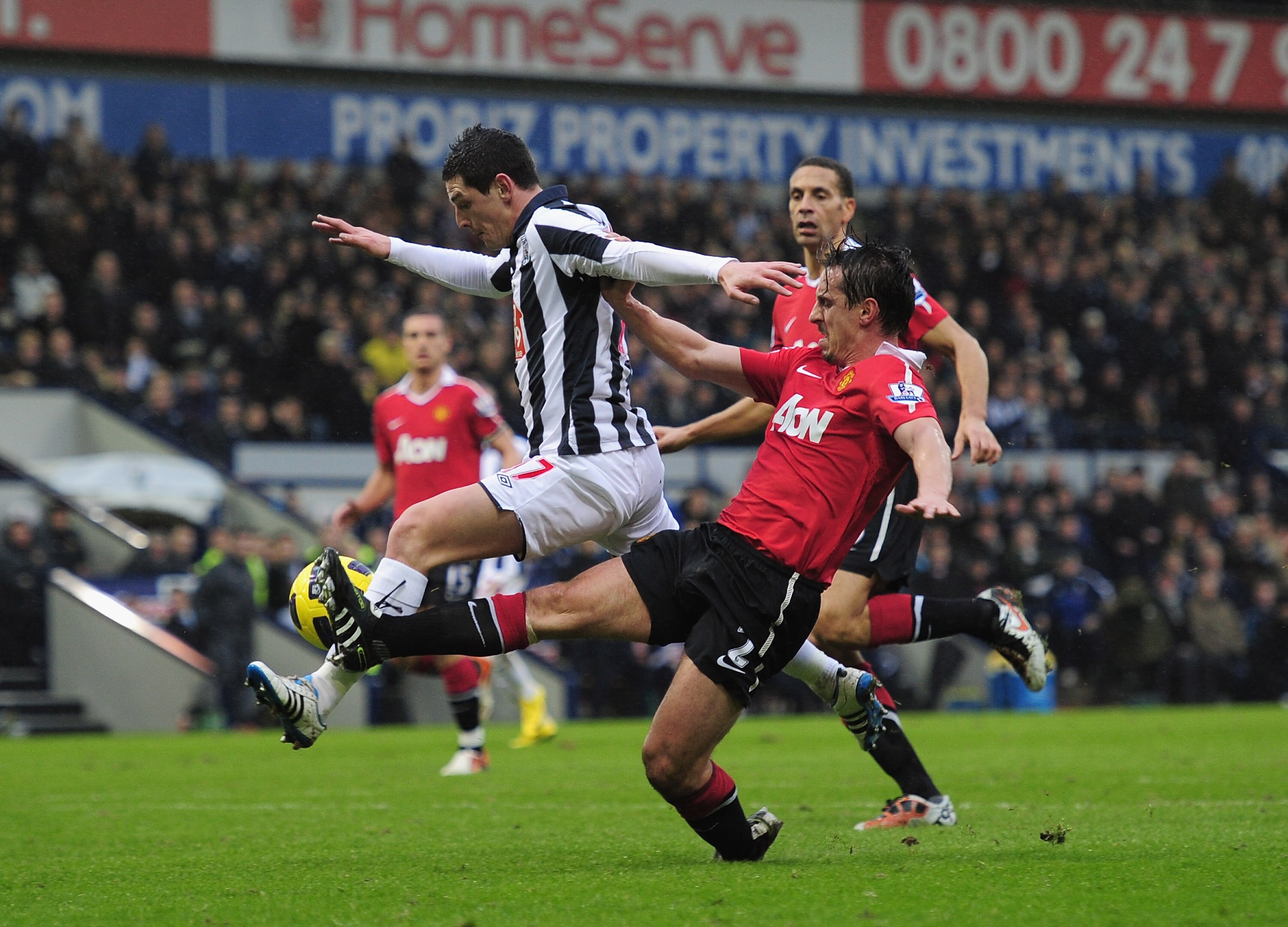 WEST BROMWICH, ENGLAND - JANUARY 01:  Gary Neville of Manchester United tackles Graham Dorrans of West Bromich Albion during the Barclays Premier League match between West Bromich Albion and Manchester United at The Hawthorns on January 1, 2011 in West Br