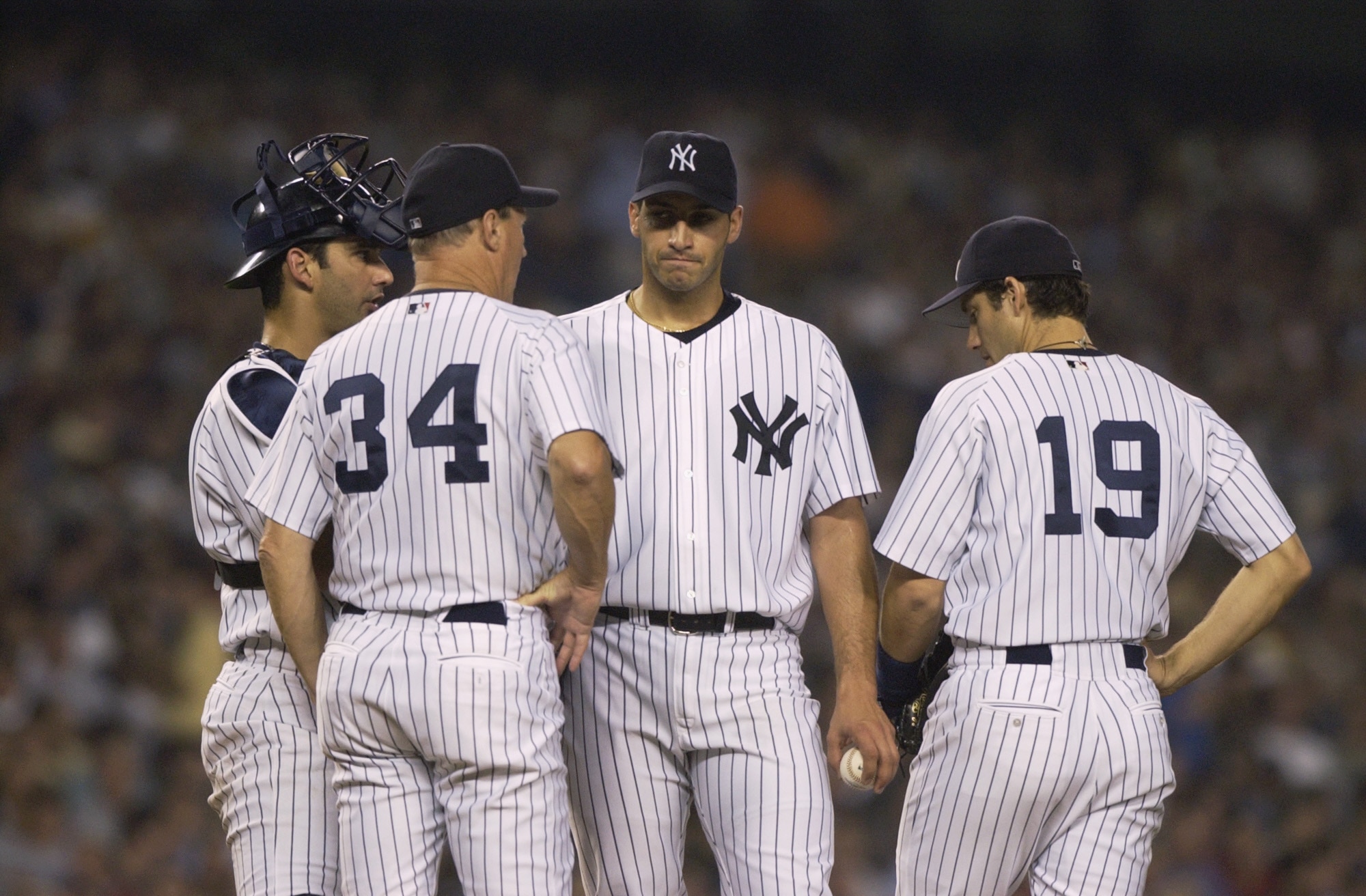 BRONX, NY - OCTOBER 2:  Starting pitcher Andy Pettitte #46 of the New York Yankees talks with pitching coach Mel Stottlemyre #34 and catcher Jorge Posada #20 as Robin Ventura #19 stands by during the third inning during game two of the American League Div