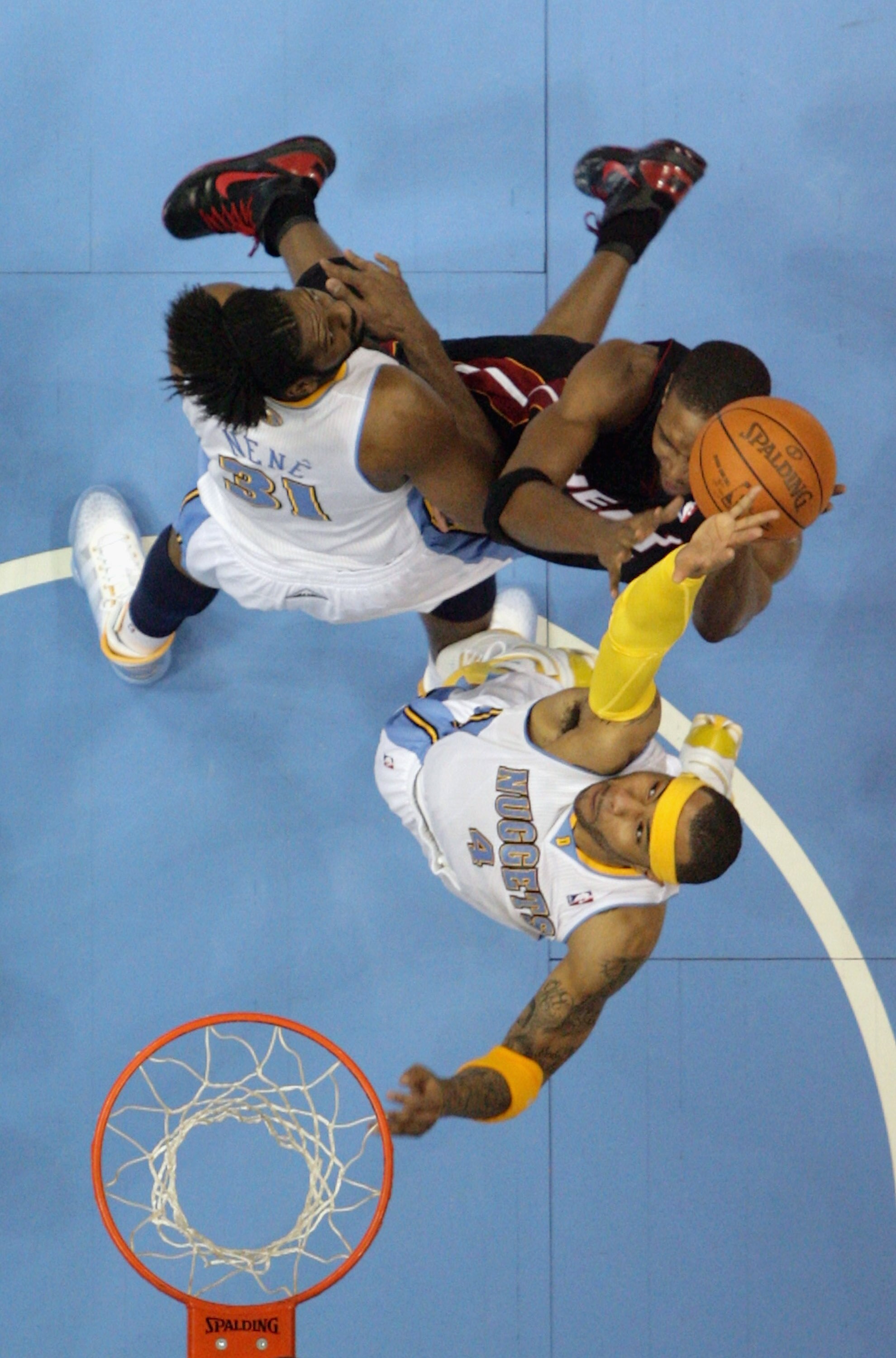DENVER, CO - JANUARY 13: Chris Bosh #1 of the Miami Heat tries to get off a shot against Kenyon Martin #4 and Nene #31 of the Denver Nuggets at the Pepsi Center on January 13, 2011 in Denver, Colorado. The Nuggets defeated the Heat 130-102. NOTE TO USER: DENVER, CO - JANUARY 13: Chris Bosh #1 of the Miami Heat tries to get off a shot against Kenyon Martin #4 and Nene #31 of the Denver Nuggets at the Pepsi Center on January 13, 2011 in Denver, Colorado. The Nuggets defeated the Heat 130-102. NOTE TO USER: