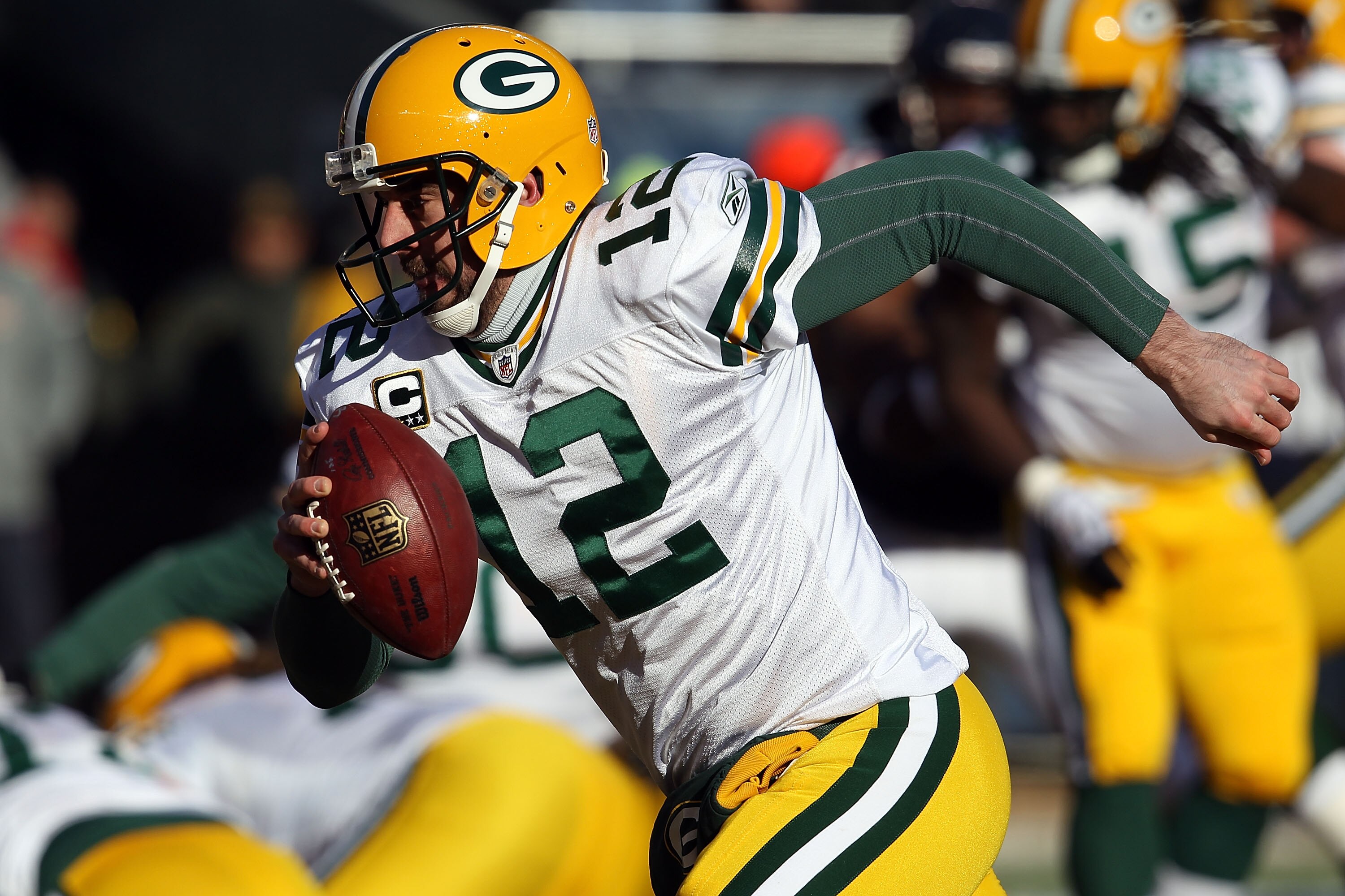 CHICAGO, IL - JANUARY 23:  Quarterback Aaron Rodgers #12 of the Green Bay Packers runs the ball to the corner of the endzone for a one-yard touchdown run against Danieal Manning #38 of the Chicago Bears in the first quarter of the NFC Championship Game at