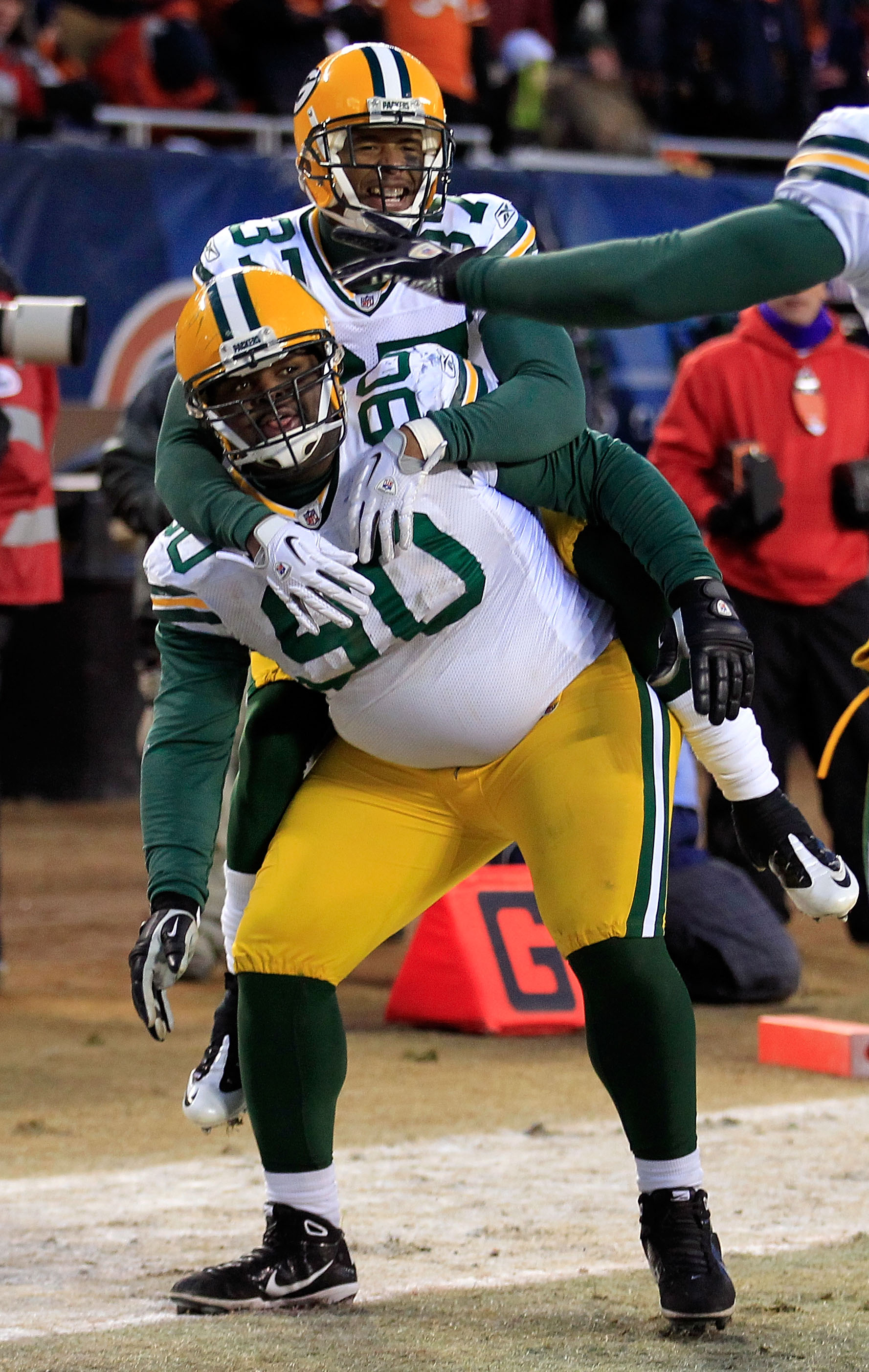 CHICAGO, IL - JANUARY 23:  B.J. Raji #90 of the Green Bay Packers reacts with teammate Sam Shields #37 after scoring on a 18-yard interception return for a touchdown in the fourth quarter against the Chicago Bears in the NFC Championship Game at Soldier F