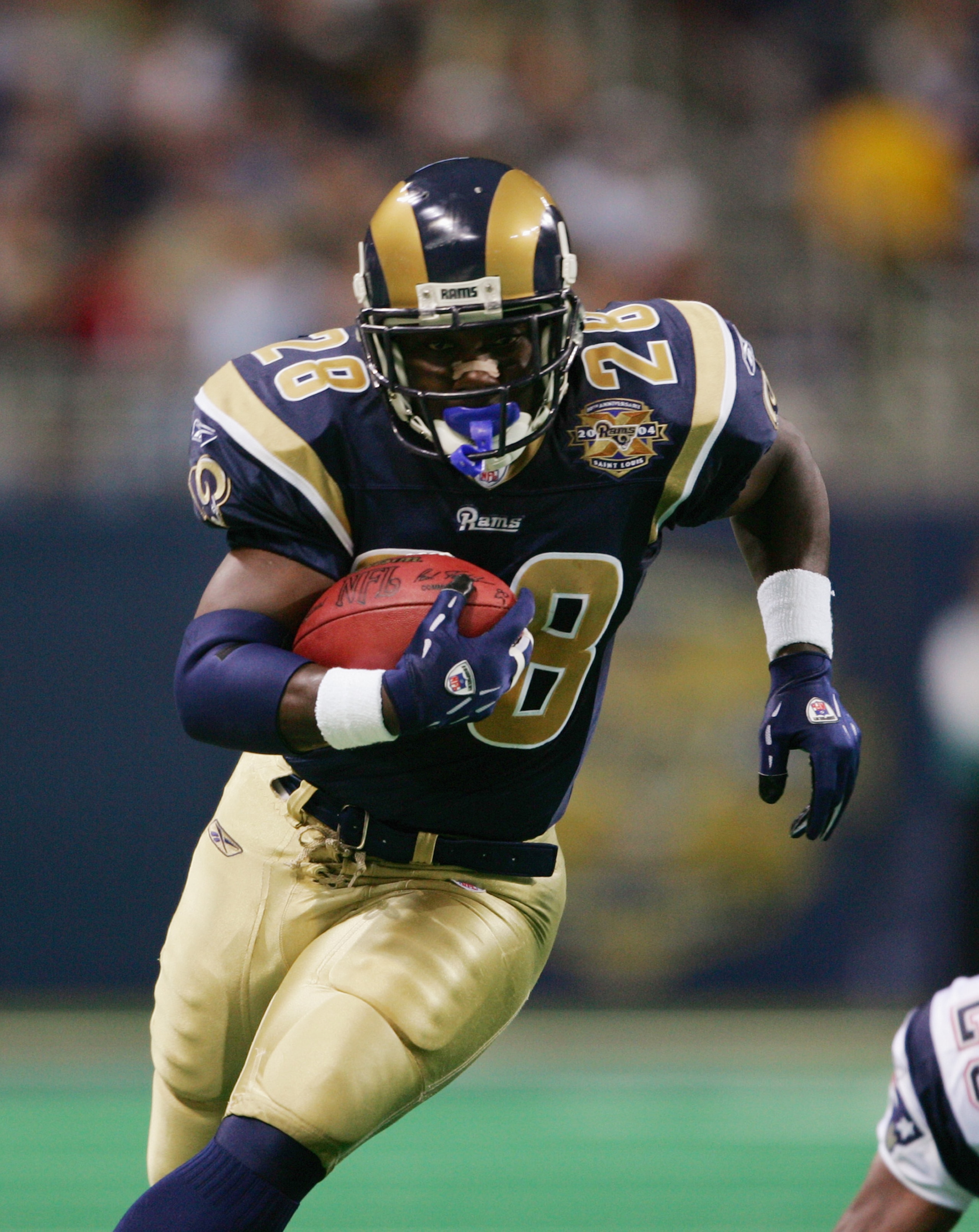 ST. LOUIS - NOVEMBER 7:   Running back Marshall Faulk #28 of the St. Louis Rams runs upfield against the New England Patriots on November 7, 2004 at the Edward Jones Dome in St. Louis, Missouri. The Patriots defeated the Rams 40-22. (Photo by Elsa/Getty I