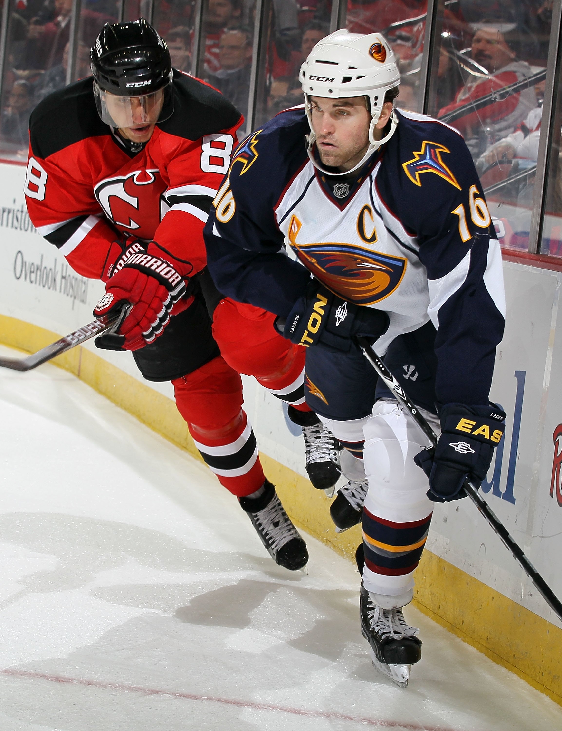 NEWARK, NJ - DECEMBER 31:  Andrew Ladd #16 of the Atlanta Thrashers skates against Dainius Zubrus #8 of the New Jersey Devils at the Prudential Center on December 31, 2010 in Newark, New Jersey. The Devils defeated the Thrashers 3-1.  (Photo by Jim McIsaa