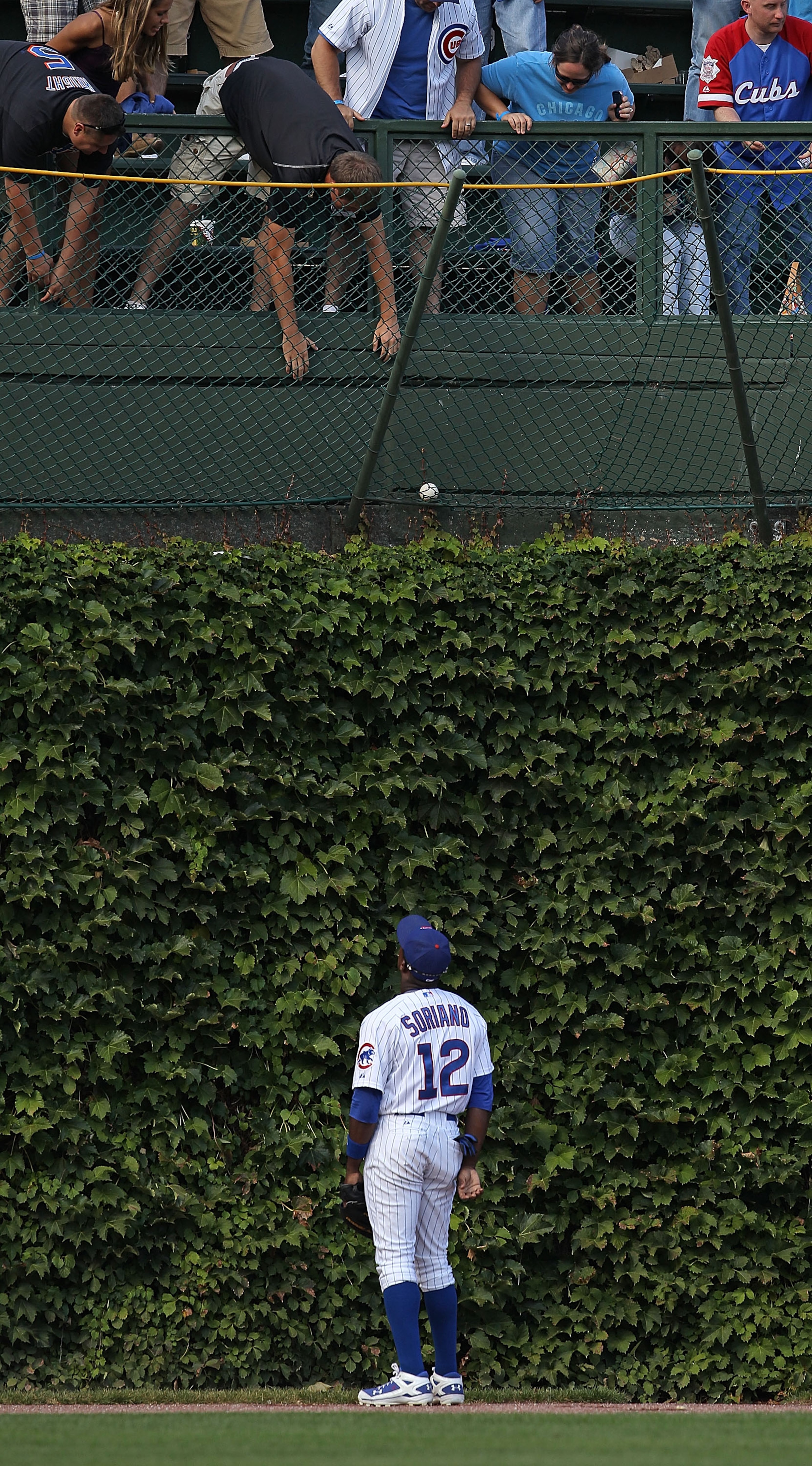 CHICAGO - SEPTEMBER 05: Alfonso Soriano #12 of the Chicago Cubs watches as fans try to grab a home run ball hit by Ike Davis of the New York Mets out of the basket in left field at Wrigley Field on September 5, 2010 in Chicago, Illinois. (Photo by Jonatha CHICAGO - SEPTEMBER 05: Alfonso Soriano #12 of the Chicago Cubs watches as fans try to grab a home run ball hit by Ike Davis of the New York Mets out of the basket in left field at Wrigley Field on September 5, 2010 in Chicago, Illinois. (Photo by Jonatha