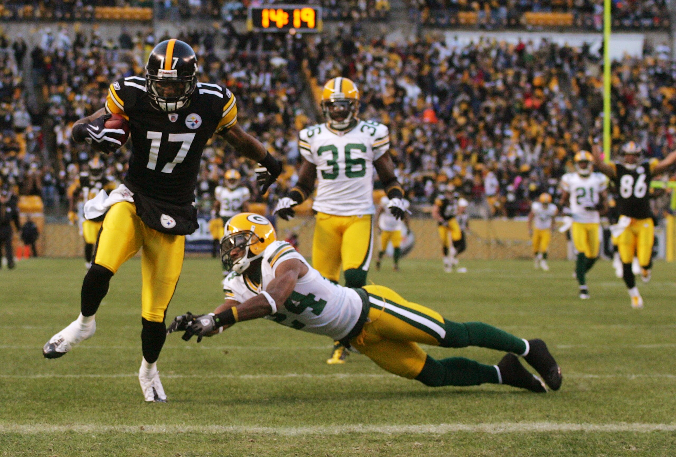 PITTSBURGH - DECEMBER 20:  Mike Wallace #17 of the Pittsburgh Steelers runs for a touchdown as Jarrett Bush #24 of the Green Bay Packers attempts to tackle in the first quarter during the game on December 20, 2009 at Heinz Field in Pittsburgh, Pennsylvani