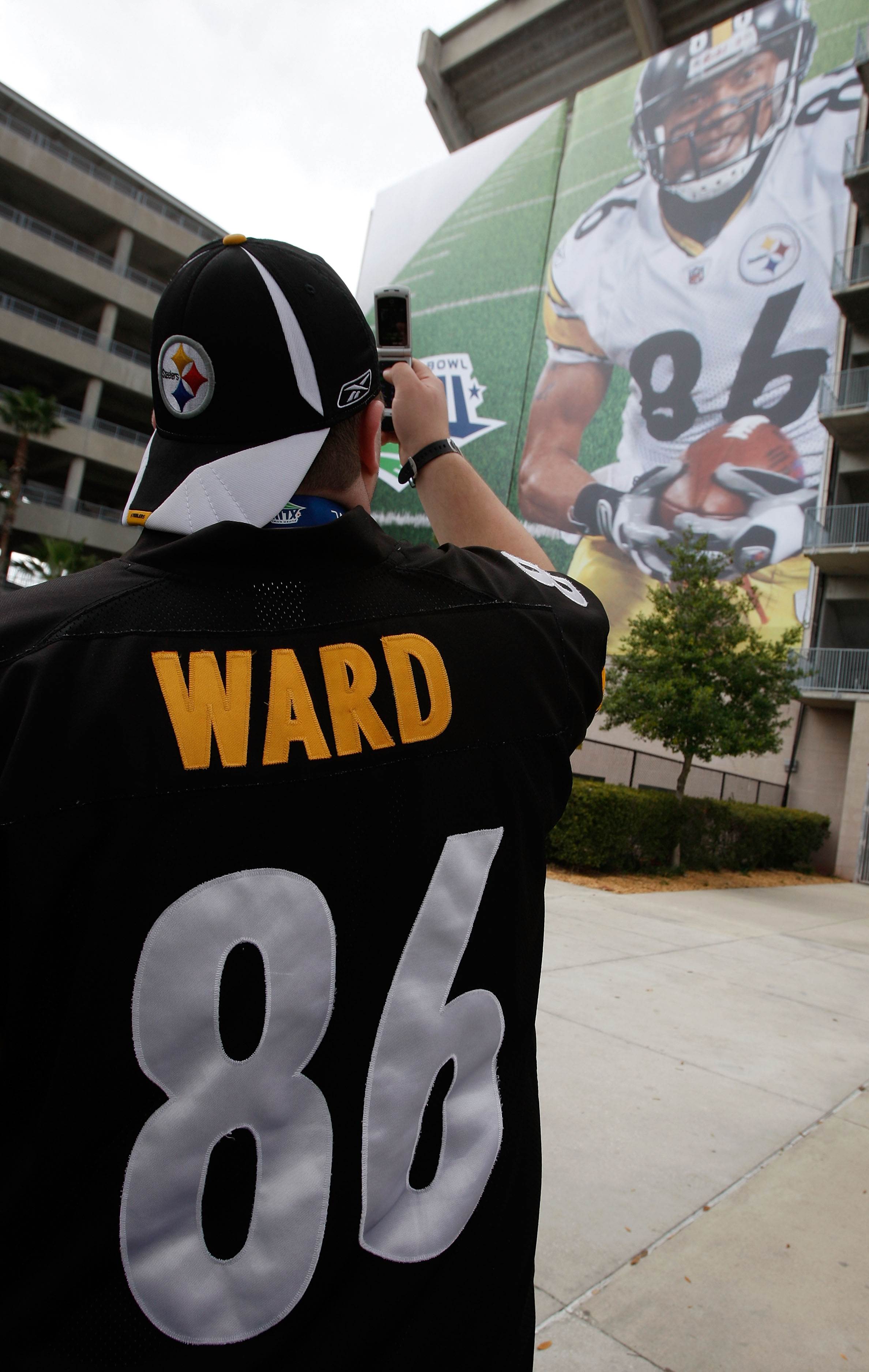 TAMPA, FL - FEBRUARY 01:  A fan of the Pittsburgh Steelers wearing a Hines Ward #86 jersey takes a photo of signage with the likeness of Hines Ward on it outside the stadium prior to Super Bowl XLIII against the Arizona Cardinals on February 1, 2009 at Ra