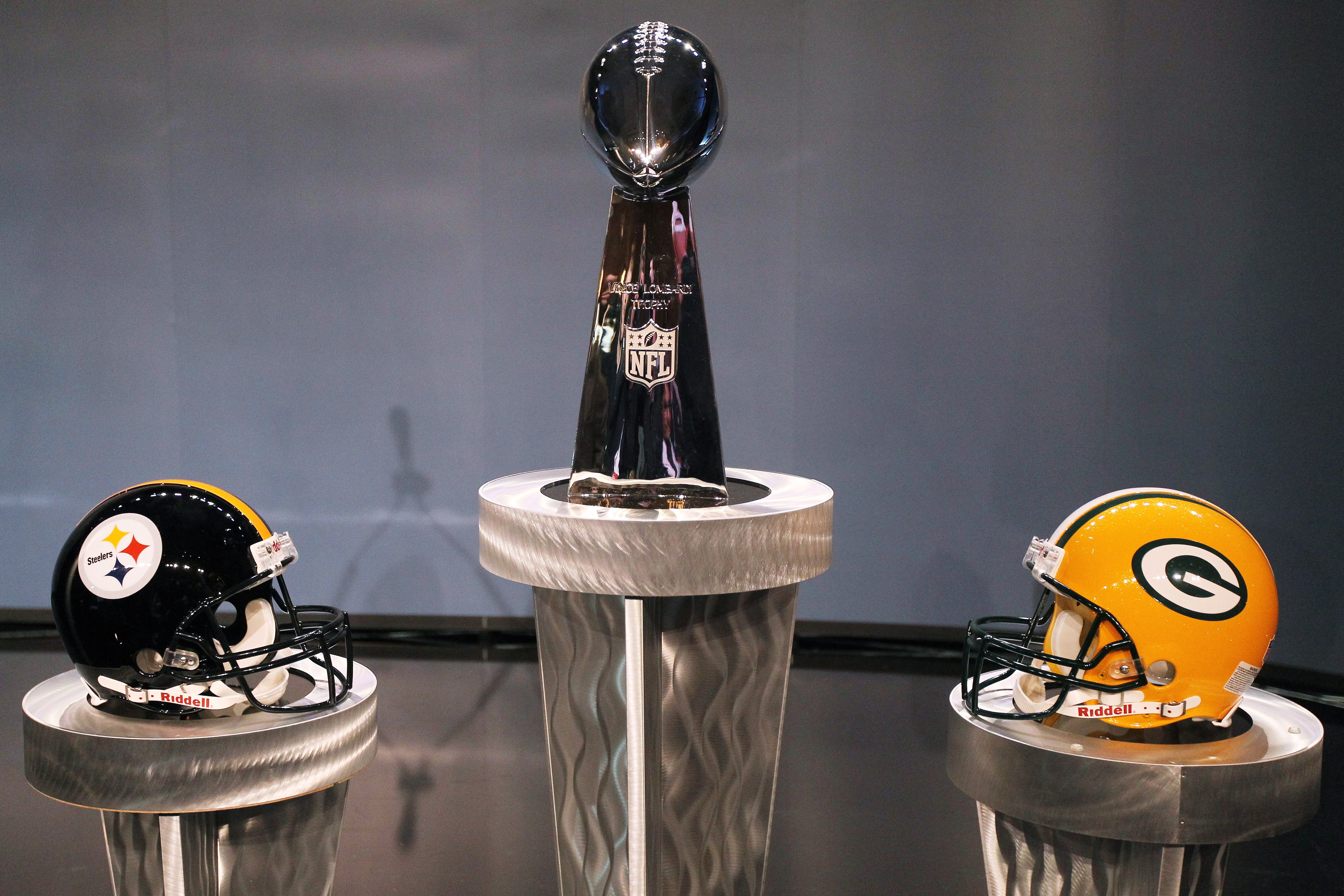 DALLAS, TX - FEBRUARY 04:  The Vince Lombardi Trophy is displayed between a Pittsburgh Steelers helmet and a Green Bay Packers helmet during a press conference with NFL commissioner Roger Goodell at the Super Bowl XLV media center on February 4, 2011 in D