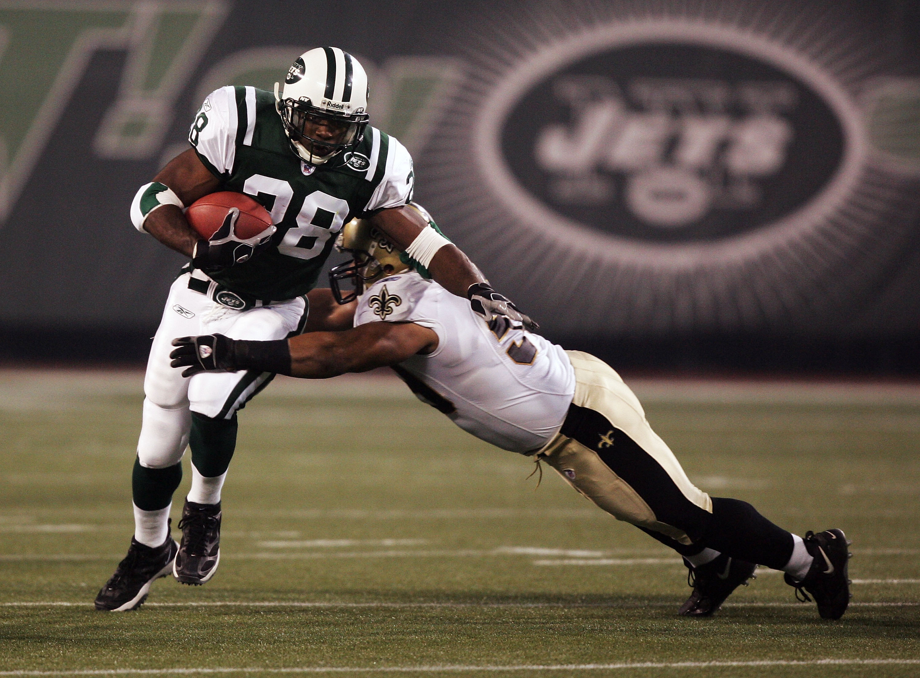 EAST RUTHERFORD, NJ - NOVEMBER 27:  Curtis Martin #28 of the New York Jets breaks a tackle against Ronald McKinnon #59 of the New Orleans Saints during their game on November 27, 2005 at Giants Stadium in East Rutherford, New Jersey.  (Photo by Al Bello/G