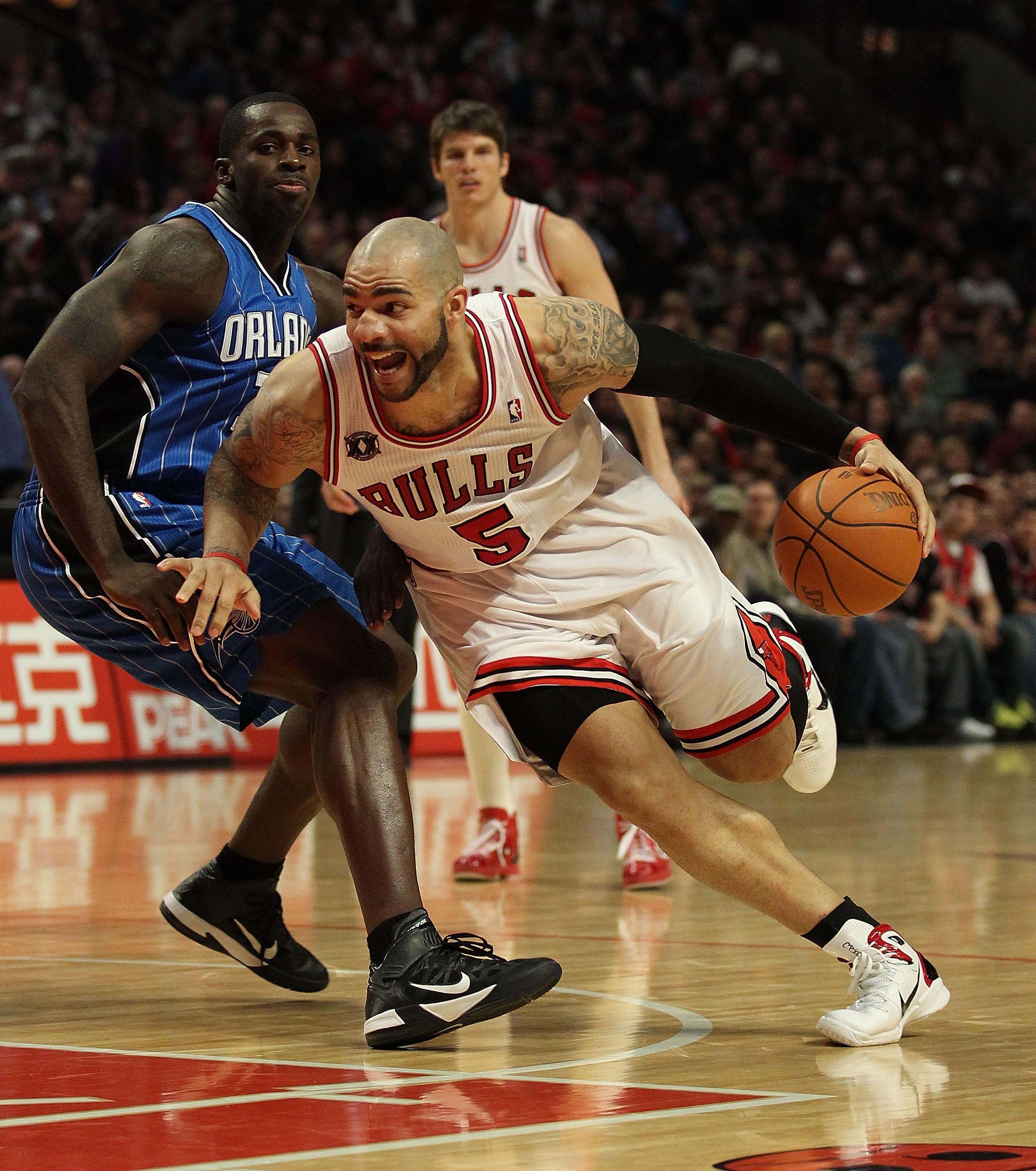 CHICAGO, IL - JANUARY 28: Carlos Boozer #5 of the Chicago Bulls drives past Brandon Bass #30 of the Orlando Magic at the United Center on January 28, 2011 in Chicago, Illinois. The Bulls defeated the Magic 99-90. NOTE TO USER: User expressly acknowledges 