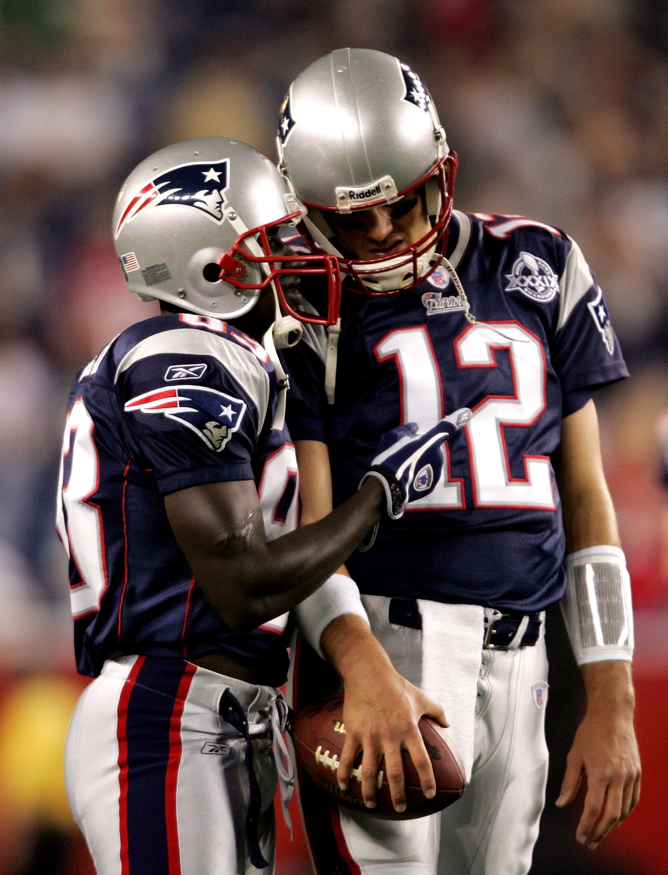 FOXBORO, MA - SEPTEMBER 8:  Quarterback Tom Brady #12 of the New England Patriots talks with his teammate, wide receiver Deion Branch #83, before the 2005 NFL opening game against the Oakland Raiders at Gillette Stadium on September 8, 2005 in Foxboro, Ma