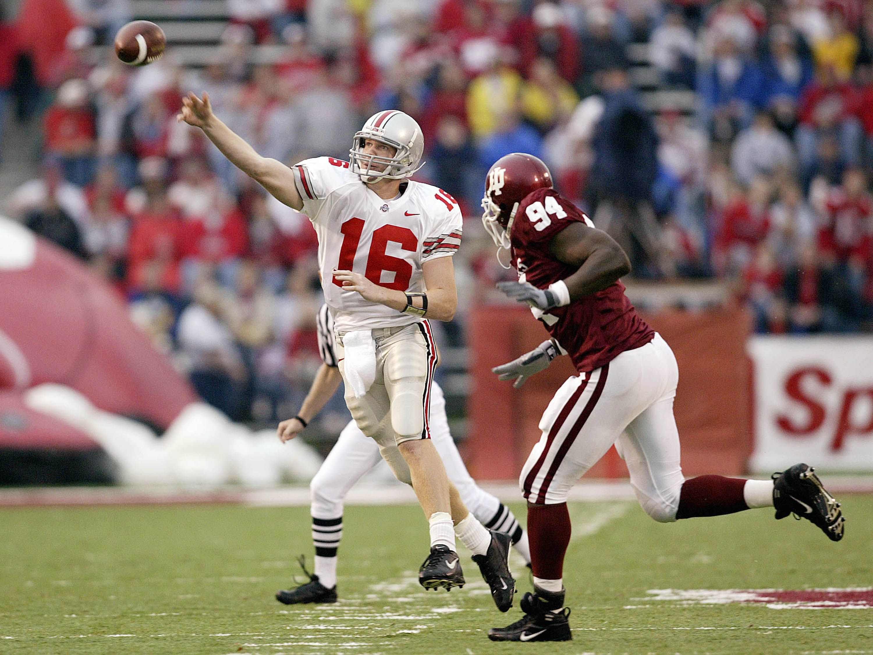 BLOOMINGTON, IN - OCTOBER 25:  Quarterback Craig Krenzel #16 of Ohio State throws a pass while being pursued by Victor Adeyanju #94 of Indiana on October 25, 2003 at Memorial Stadium in Bloomington, Indiana. Ohio State won 35-6. (Photo by Jeff Gross/Getty