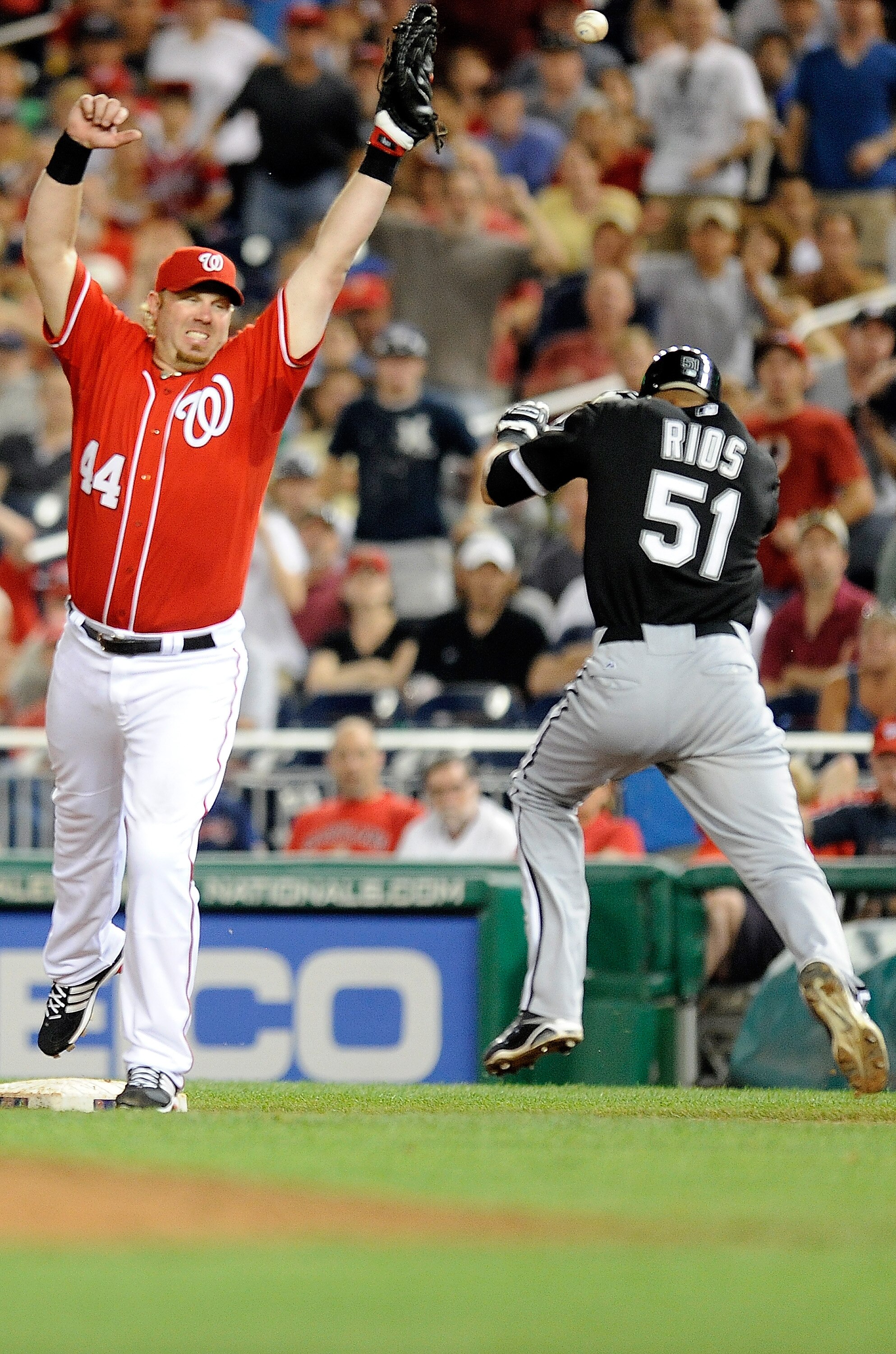 WASHINGTON - JUNE 18:  Adam Dunn #44 of the Washington Nationals reaches for an errant throw as Alex Rios #51 of the Chicago White Sox is safe at first base during the eleventh inning of the game at Nationals Park on June 18, 2010 in Washington, DC. Rios
