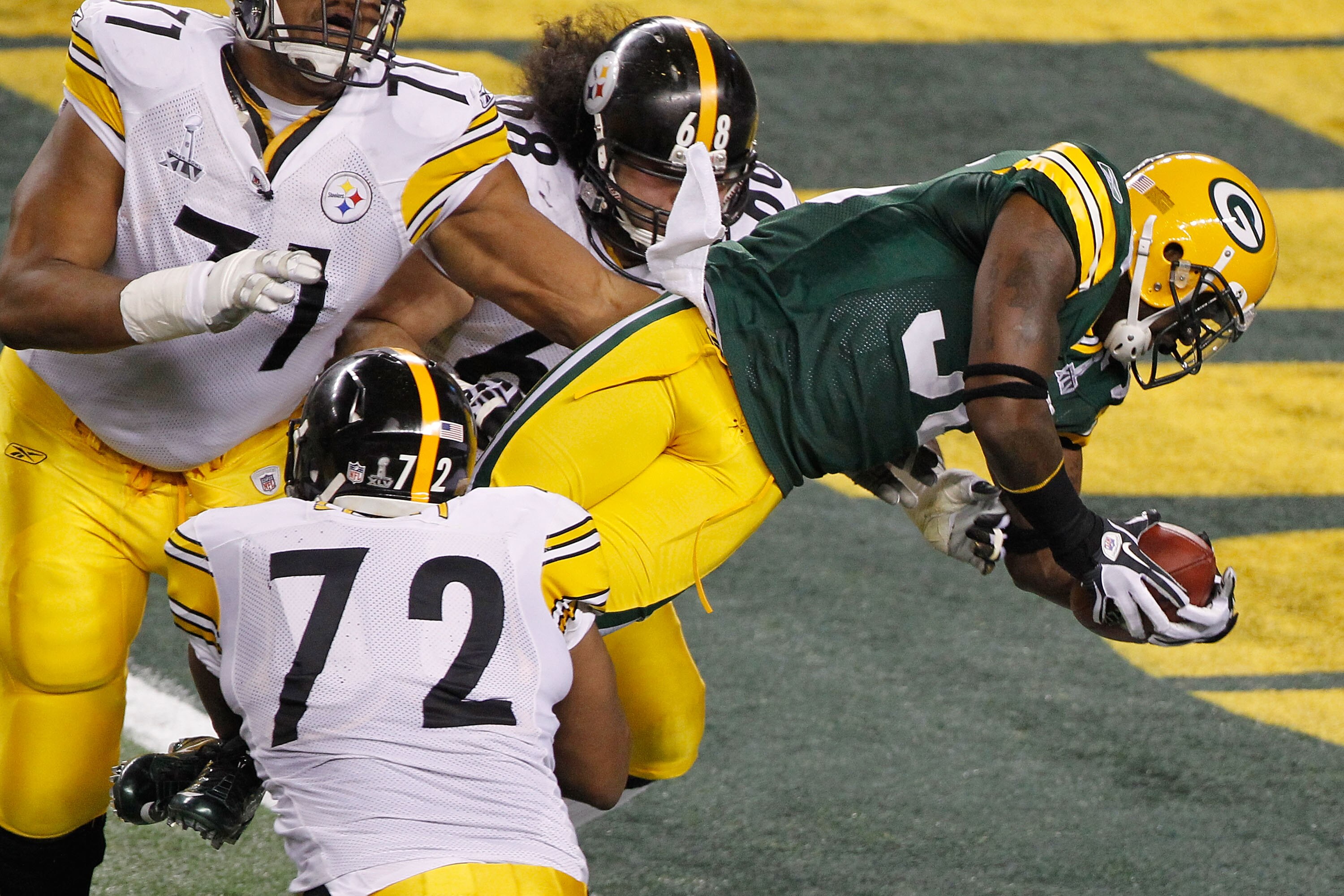 ARLINGTON, TX - FEBRUARY 06:  Nick Collins #36 of the Green Bay Packers runs 37 yards for a touchdown after making an interception as he is tackled by Jonathan Scott #72 and Chris Kemoeatu #68 of the Pittsburgh Steelers in the first quarter against the Pi