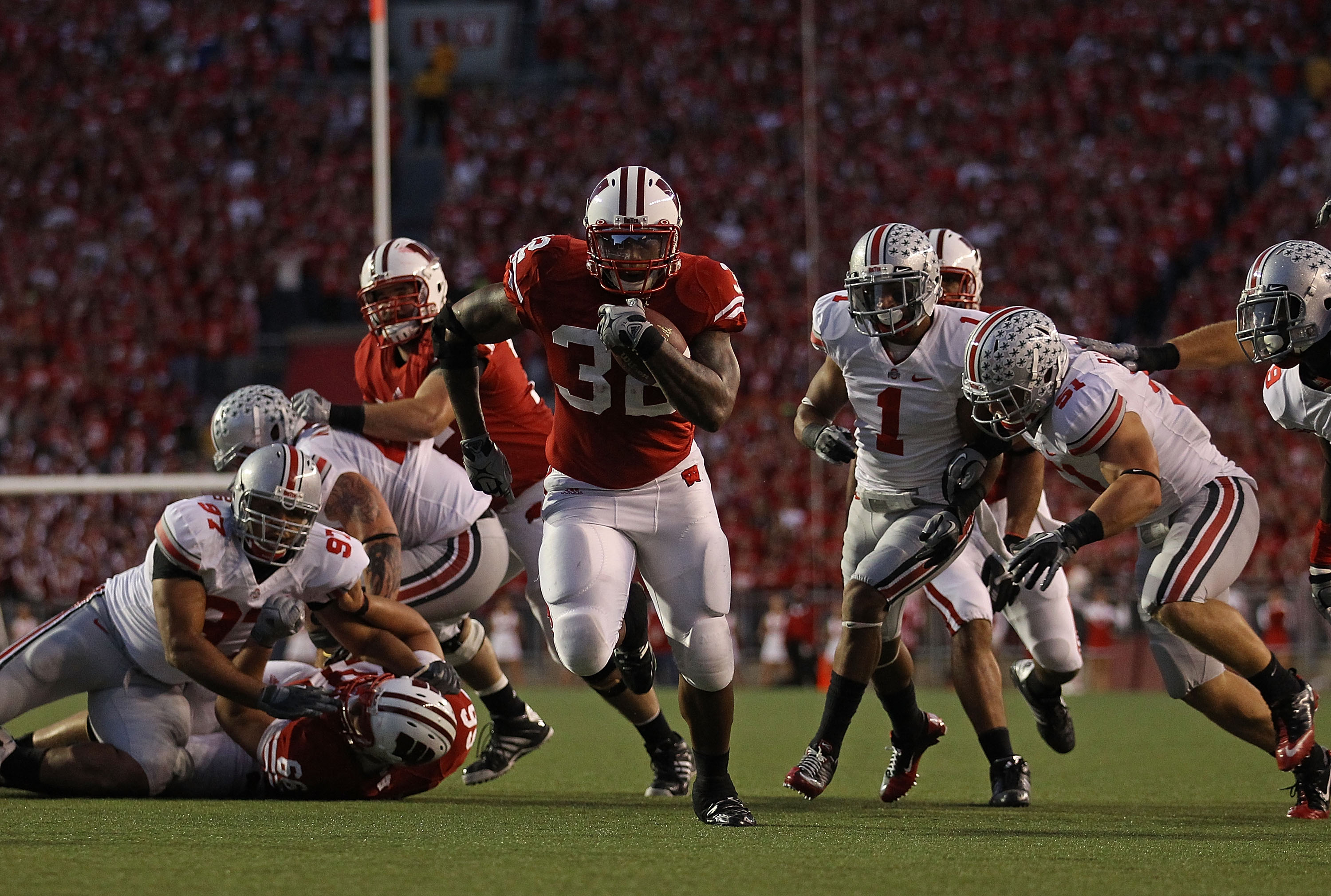 MADISON, WI - OCTOBER 16: John Clay #32 of the Wisconsin Badgers runs past Ross Homan #51 and Devon Torrence #1 of the Ohio State Buckeyes for a touchdown at Camp Randall Stadium on October 16, 2010 in Madison, Wisconsin. (Photo by Jonathan Daniel/Getty I