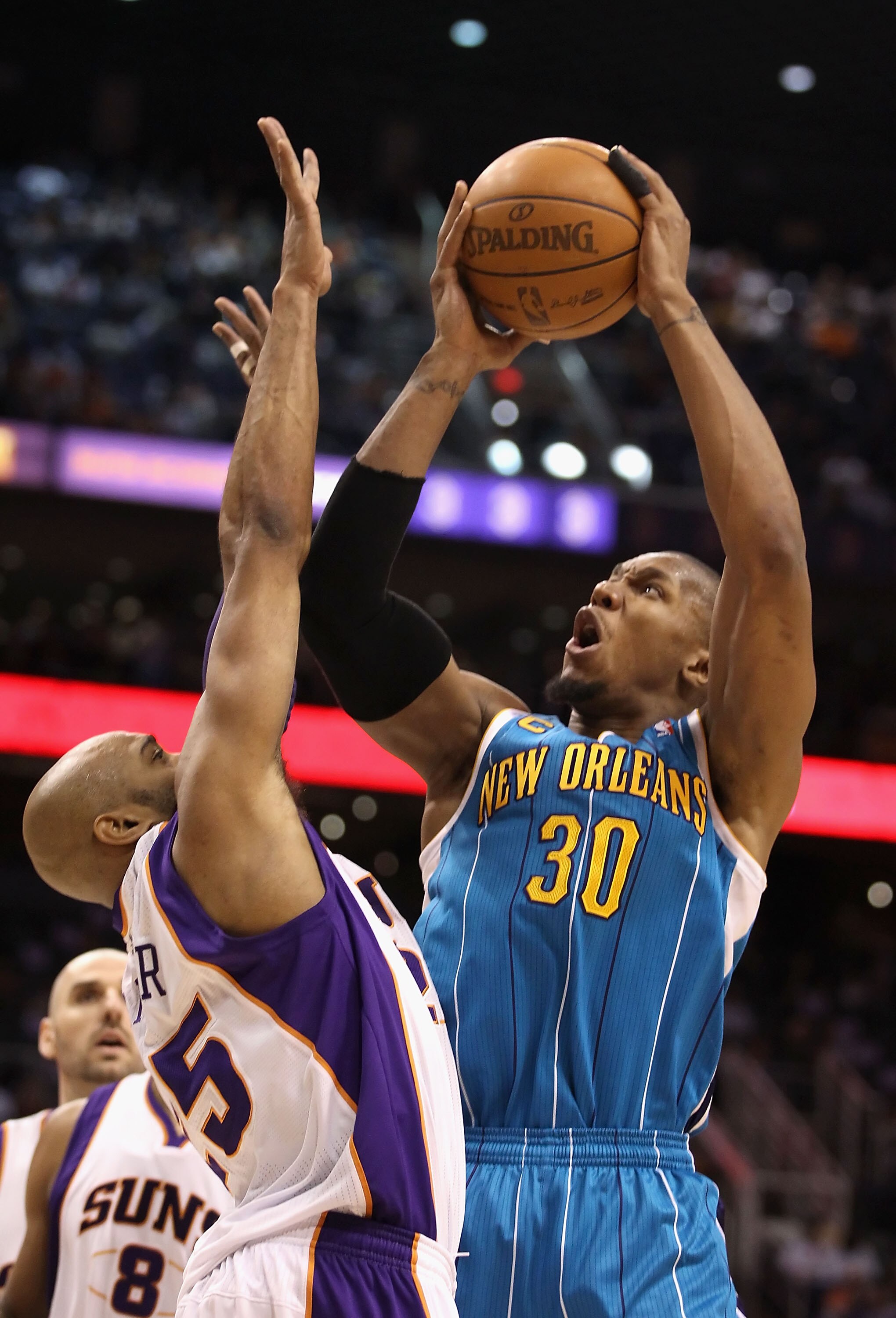 PHOENIX, AZ - JANUARY 30:  David West #30 of the New Orleans Hornets puts up a shot over Vince Carter #25 of the Phoenix Suns during the NBA game at US Airways Center on January 30, 2011 in Phoenix, Arizona.  NOTE TO USER: User expressly acknowledges and 