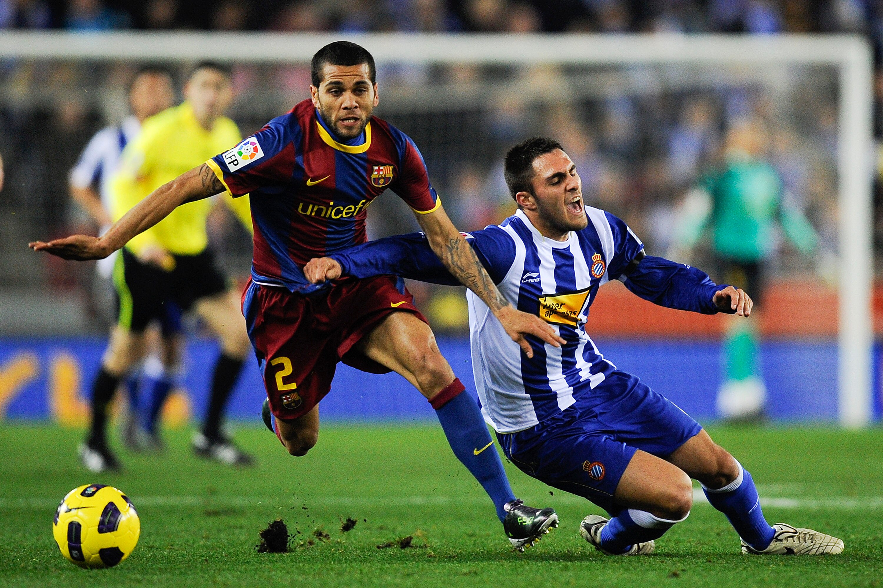 BARCELONA, SPAIN - DECEMBER 18: Dani Alves of Barcelona (L) and Victor Ruiz of Espanyol duel for a ball during the La Liga match between Espanyol and Barcelona at Cornella - El Prat stadium on December 18, 2010 in Barcelona, Spain. Barcelona won the match