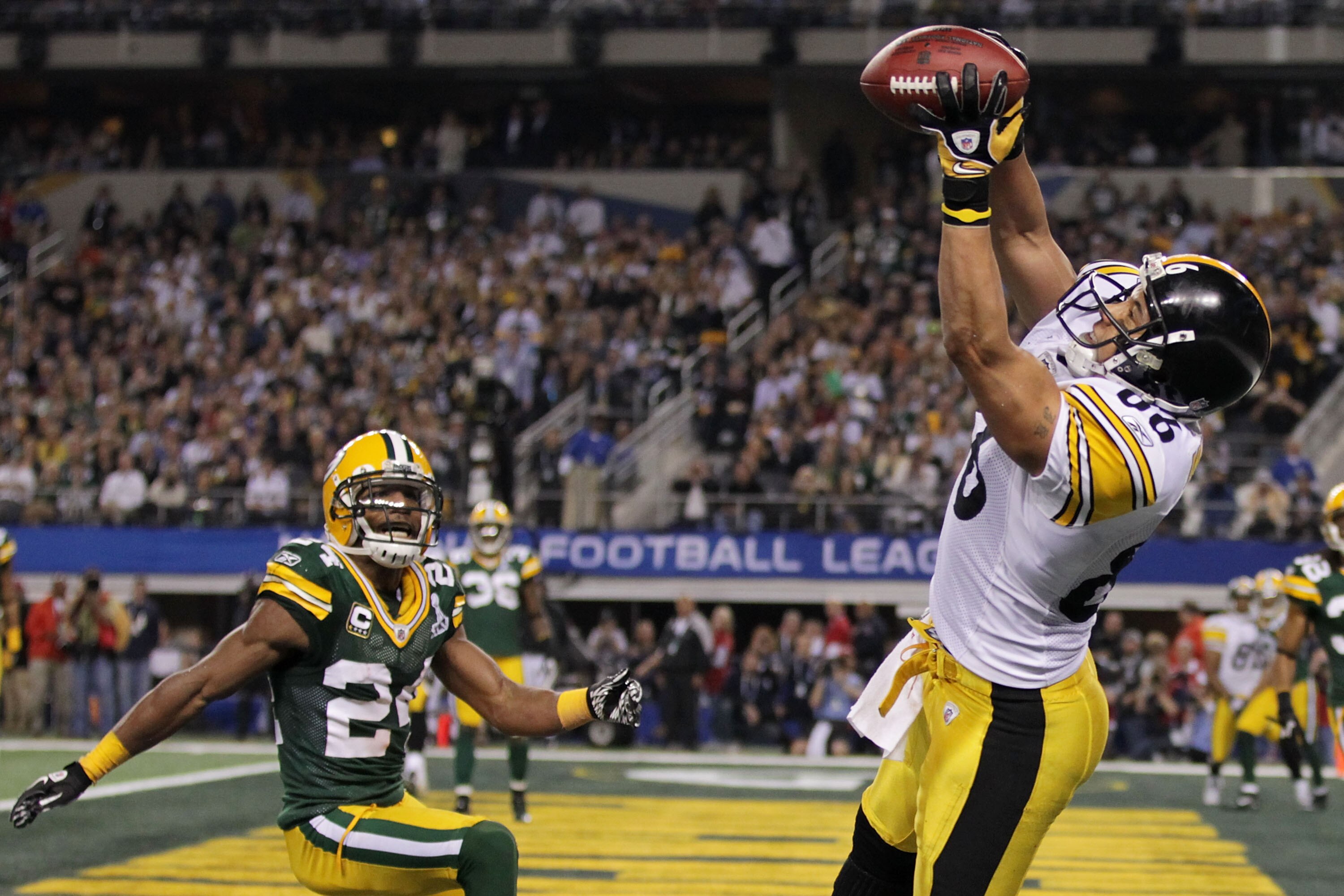 ARLINGTON, TX - FEBRUARY 06:  Hines Ward #86 of the Pittsburgh Steelers catches an eight yard touchdown pass in the second quarter against Jarrett Bush #24 of the Green Bay Packers in Super Bowl XLV at Cowboys Stadium on February 6, 2011 in Arlington, Tex