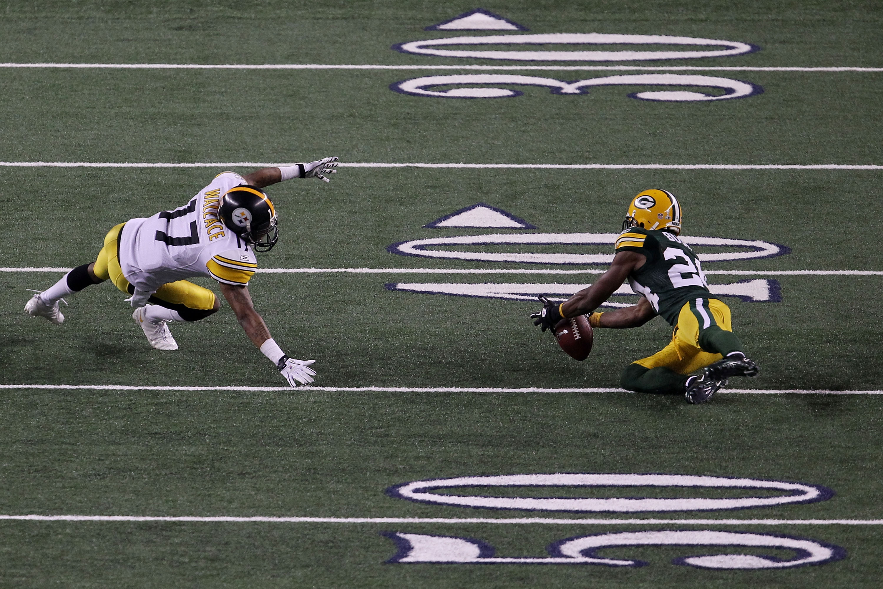 ARLINGTON, TX - FEBRUARY 06:  Jarrett Bush #24 of the Green Bay Packers intercepts a pass against Mike Wallace #17 of the Pittsburgh Steelers in the fourt quarter during Super Bowl XLV at Cowboys Stadium on February 6, 2011 in Arlington, Texas.  (Photo by