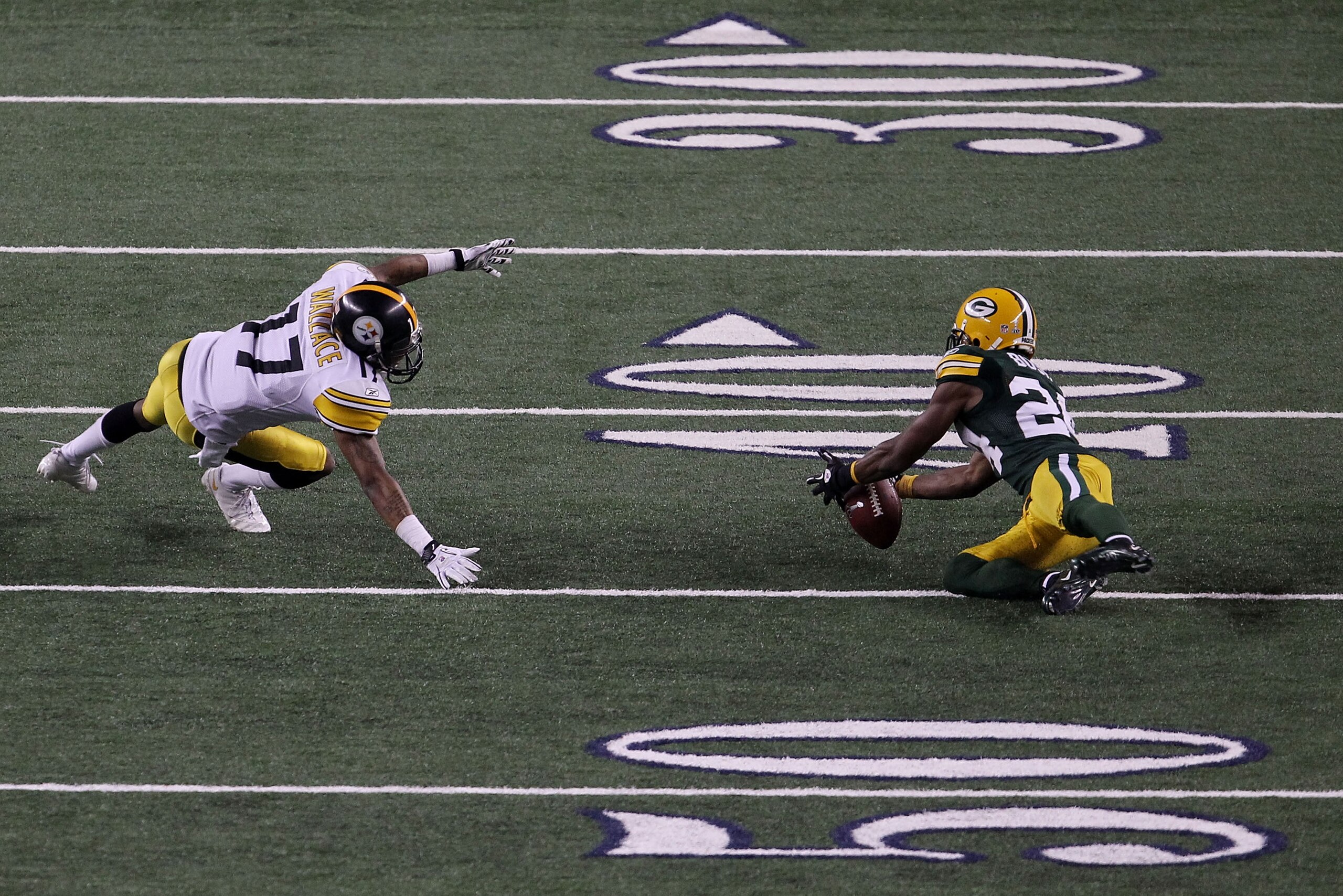 ARLINGTON, TX - FEBRUARY 06:  Jarrett Bush #24 of the Green Bay Packers intercepts a pass against Mike Wallace #17 of the Pittsburgh Steelers in the fourt quarter during Super Bowl XLV at Cowboys Stadium on February 6, 2011 in Arlington, Texas.  (Photo by