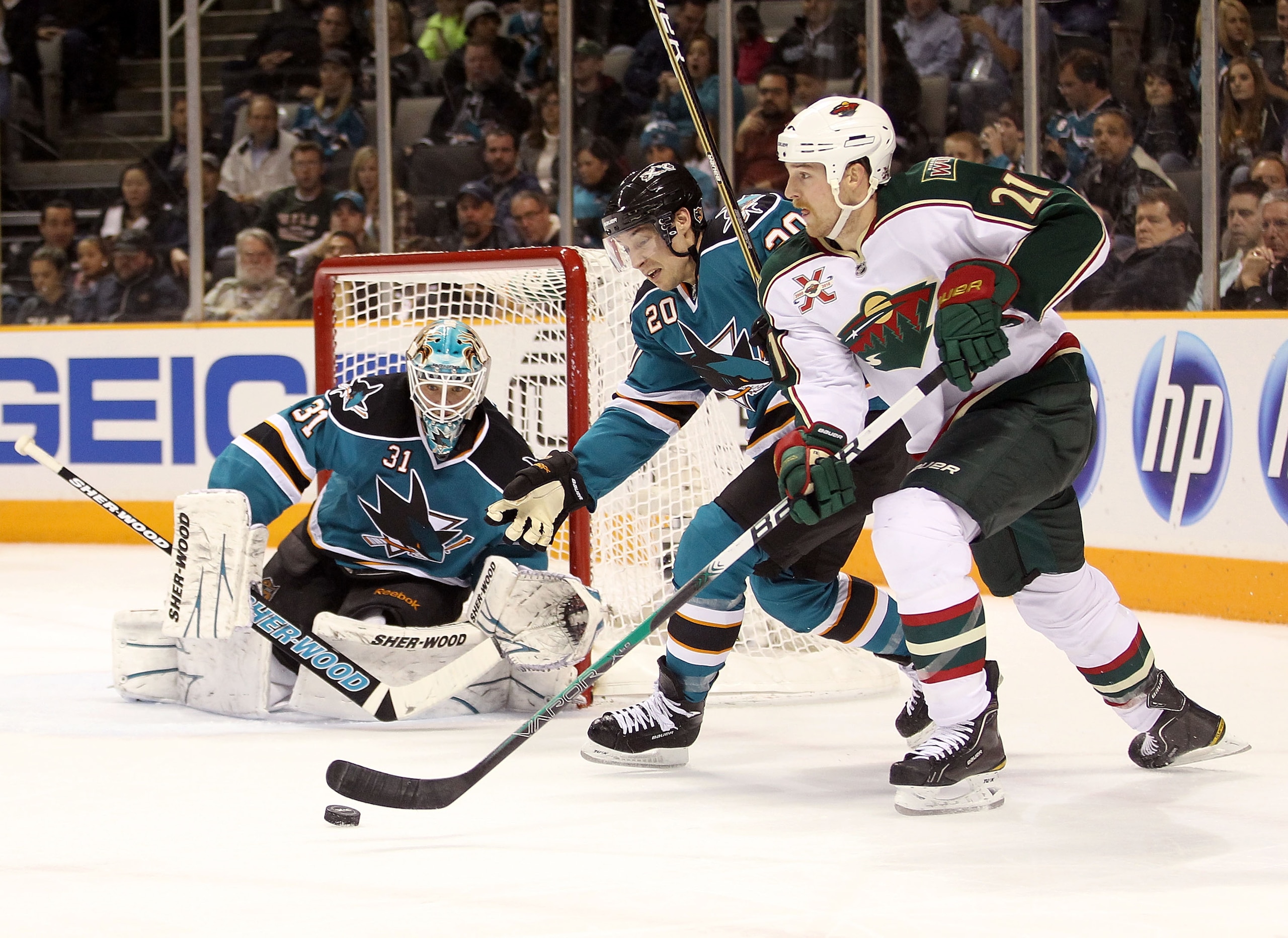 SAN JOSE, CA - JANUARY 22:  Antti Niemi #31 and Kyle Wellwood #20 of the San Jose Sharks defend against Kyle Brodziak #21 of the Minnesota Wild at HP Pavilion on January 22, 2011 in San Jose, California.  (Photo by Ezra Shaw/Getty Images)