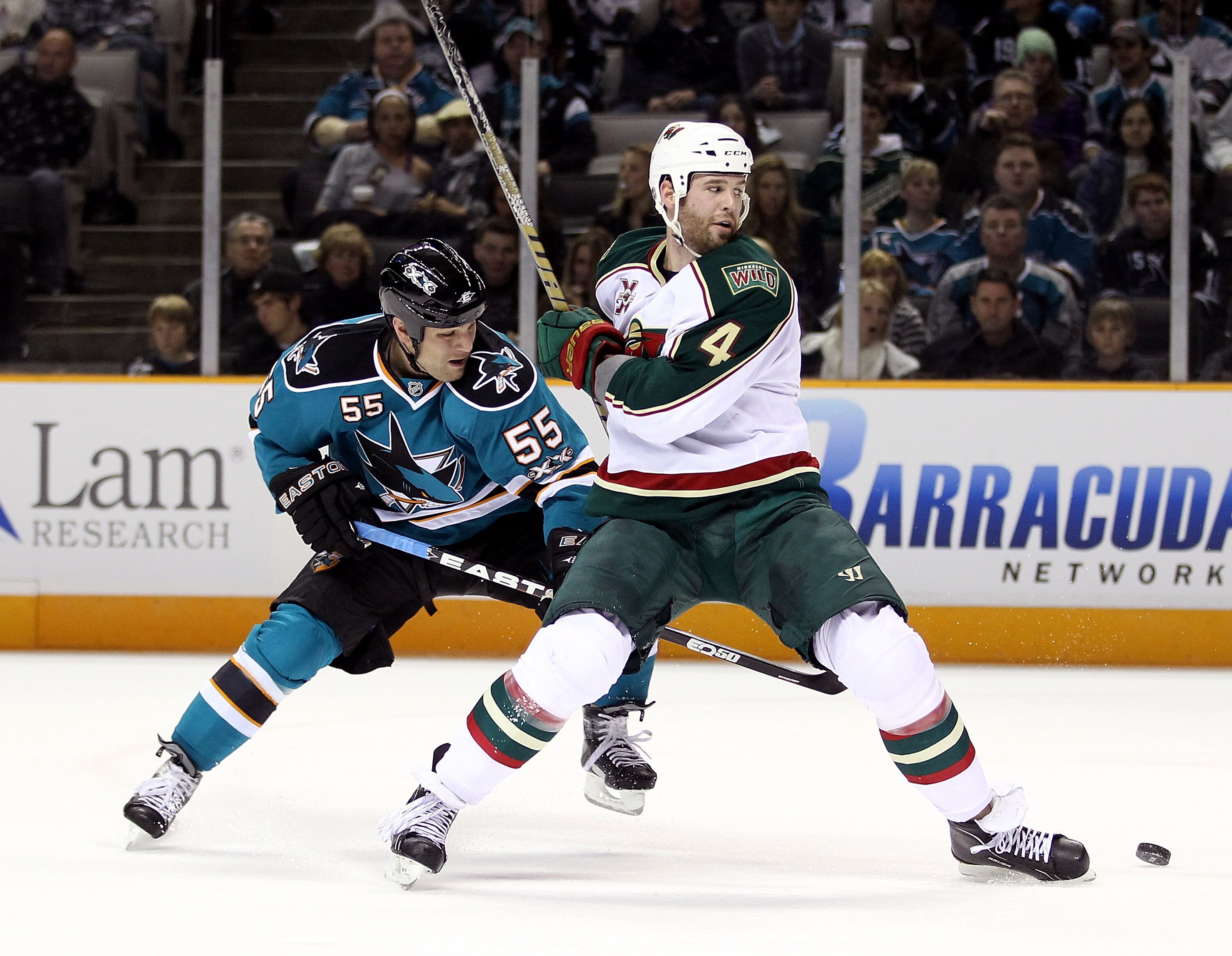 SAN JOSE, CA - JANUARY 22:  Ben Eager #55 of the San Jose Sharks and Clayton Stoner #4 of the Minnesota Wild go for the puck at HP Pavilion on January 22, 2011 in San Jose, California.  (Photo by Ezra Shaw/Getty Images)