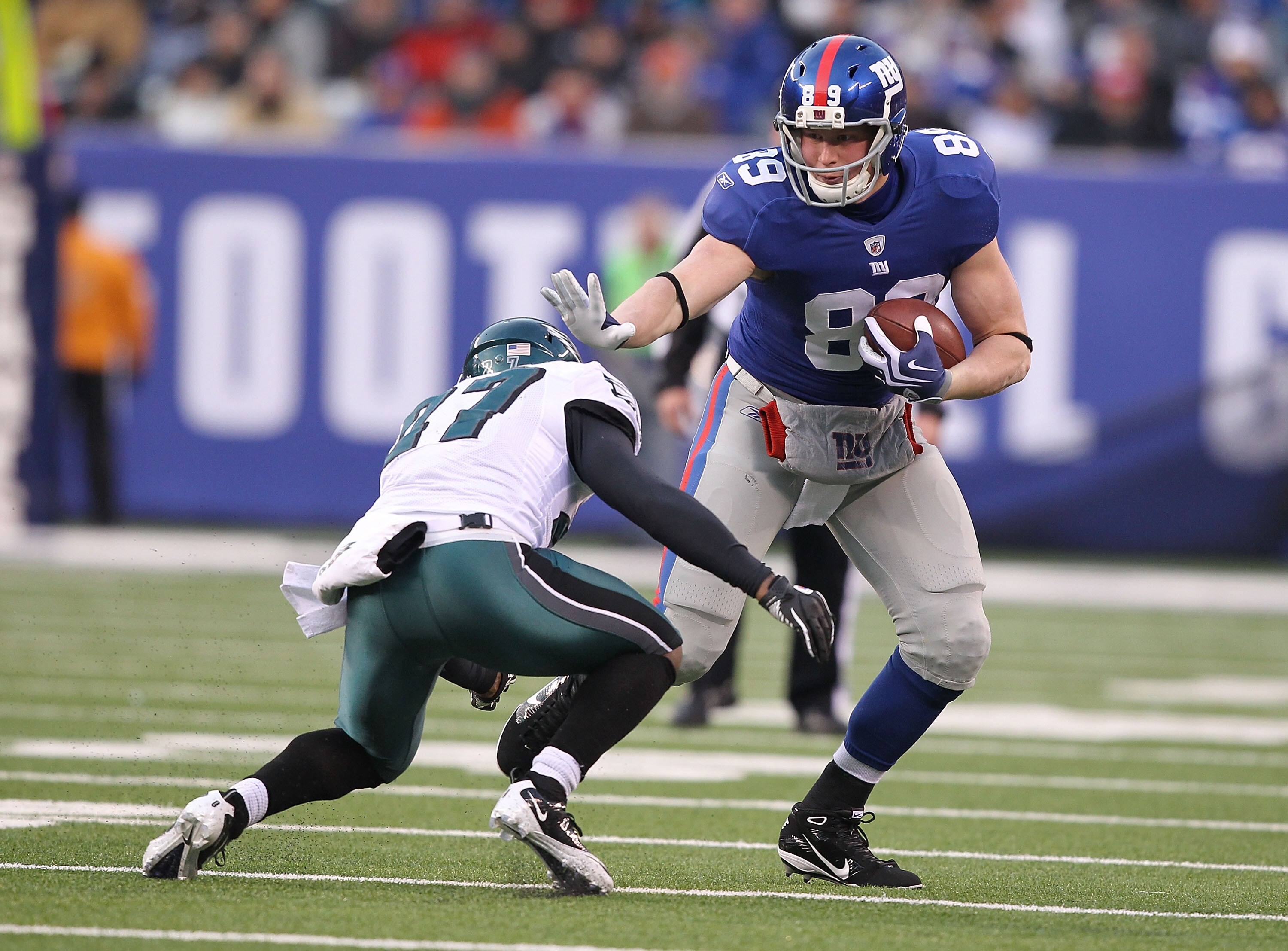 EAST RUTHERFORD, NJ - DECEMBER 19:  Kevin Boss #89 of the New York Giants stiff arms Quintin Mikell #27 of the Philadelphia Eagles during their game on December 19, 2010 at The New Meadowlands Stadium in East Rutherford, New Jersey.  (Photo by Al Bello/Ge