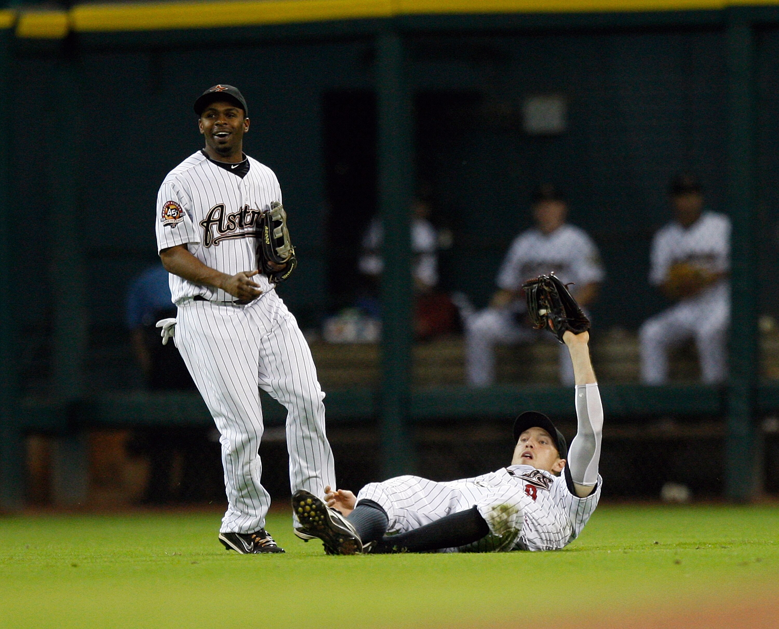 HOUSTON - AUGUST 19:  Left fielder Hunter Pence #9 of the Houston Astros makes a sliding catch in front of center fielder Michael Bourn on a short fly ball hit by Jeff Francoeur of the New York Mets for the final out at Minute Maid Park on August 19, 2010