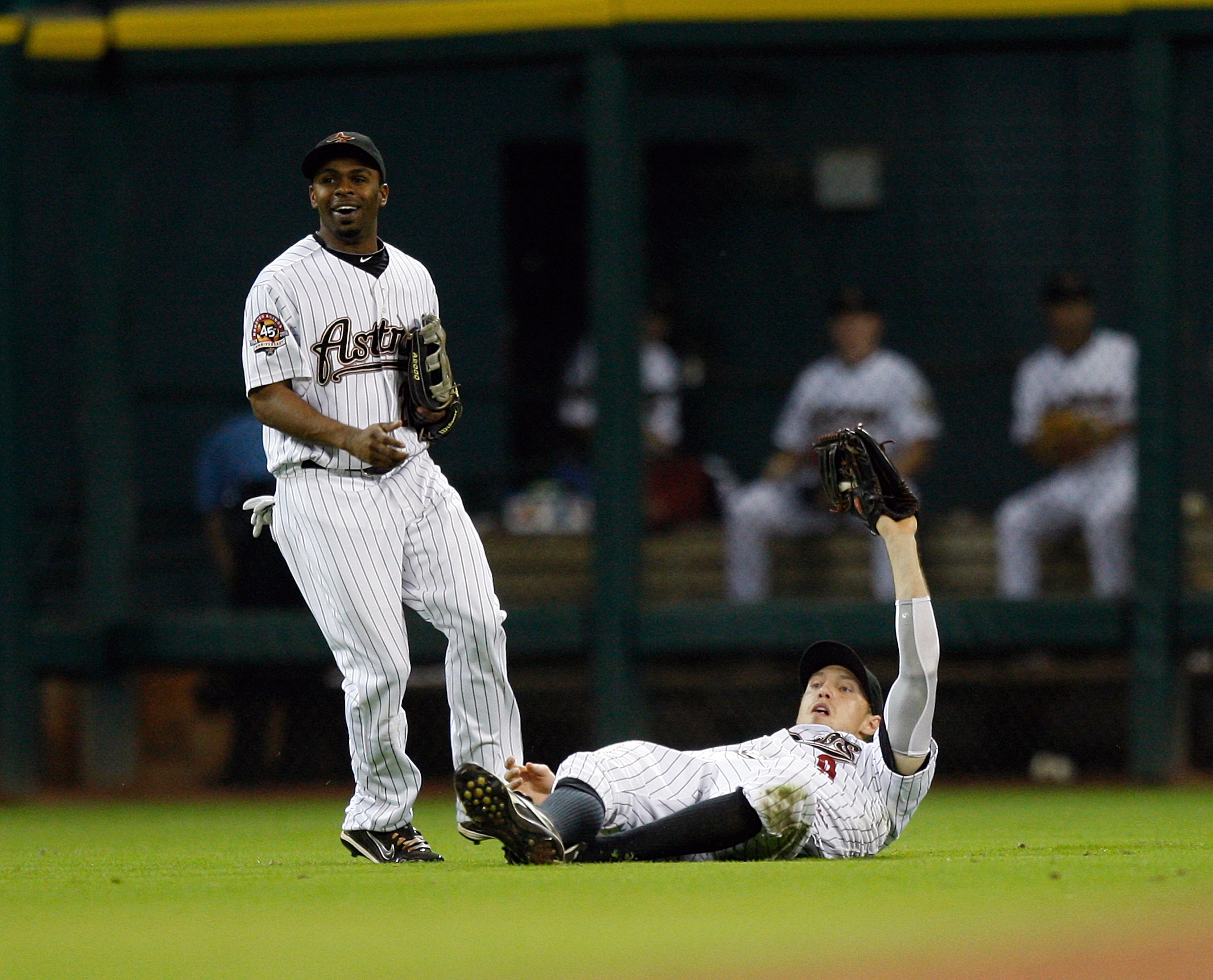 HOUSTON - AUGUST 19:  Left fielder Hunter Pence #9 of the Houston Astros makes a sliding catch in front of center fielder Michael Bourn on a short fly ball hit by Jeff Francoeur of the New York Mets for the final out at Minute Maid Park on August 19, 2010