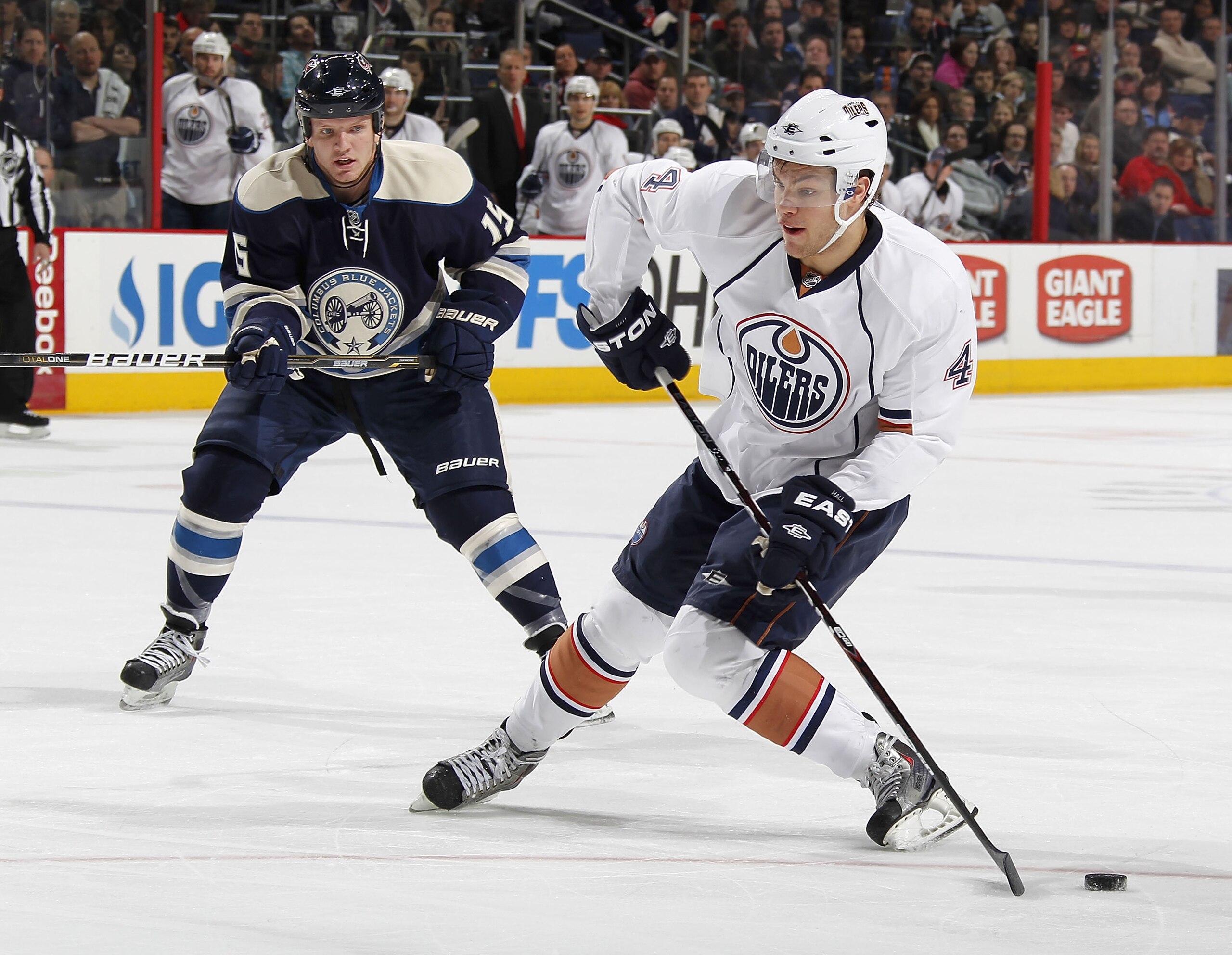 COLUMBUS, OH - FEBRUARY 05:  Taylor Hall #4 of the Edmonton Oilers tries to control the puck in front of Derek Dorsett #15 of the Columbus Blue Jackets at Nationwide Arena on February 5, 2011 in Columbus, Ohio.  (Photo by Gregory Shamus/Getty Images)