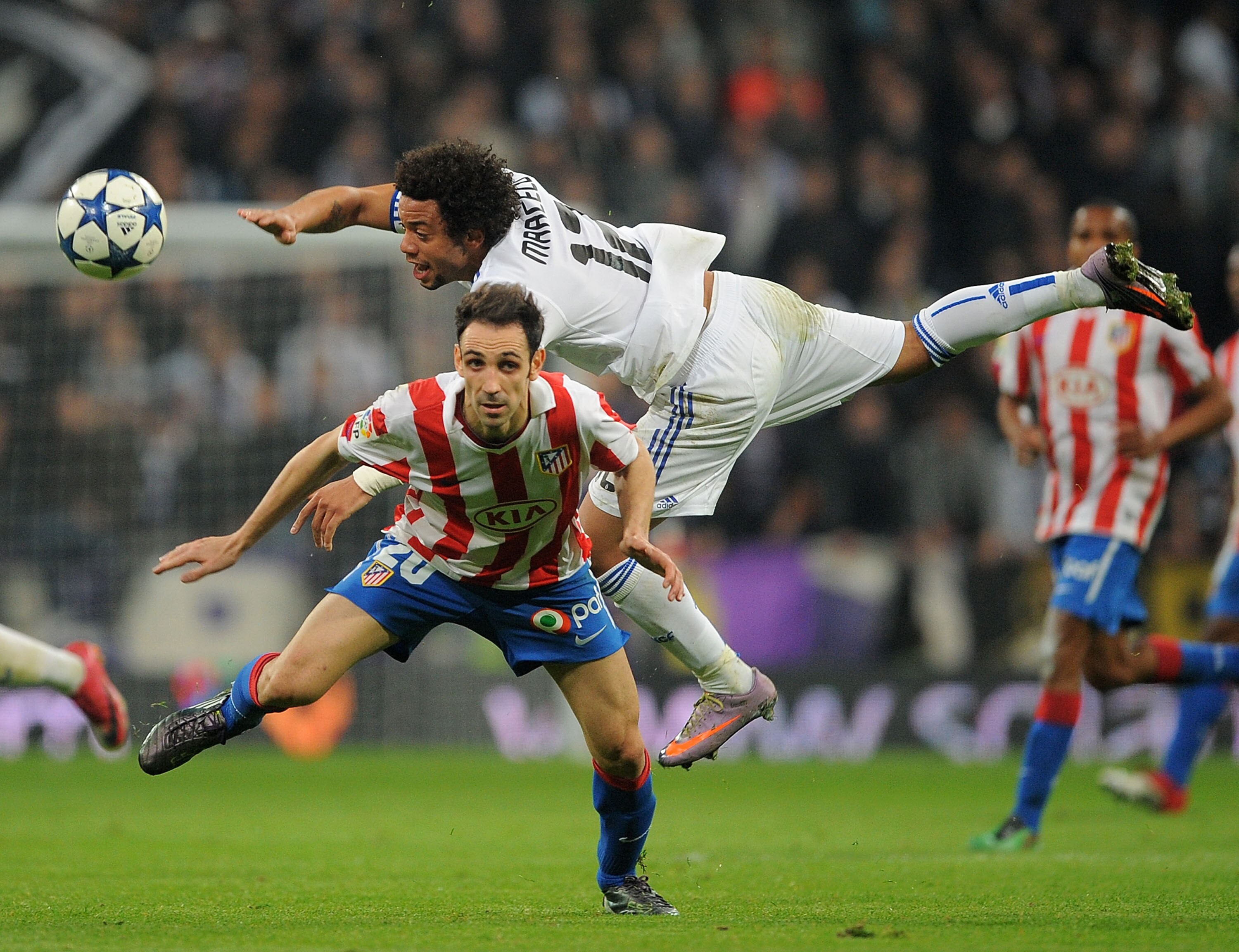 MADRID, SPAIN - JANUARY 13:  Juanfran (L) of Atletico Madrid is challenged by Marcelo of Real Madrid during the Copa del Rey quarter final first leg match between Real Madrid and Atletico Madrid at Estadio Santiago Bernabeu on January 13, 2011 in Madrid,
