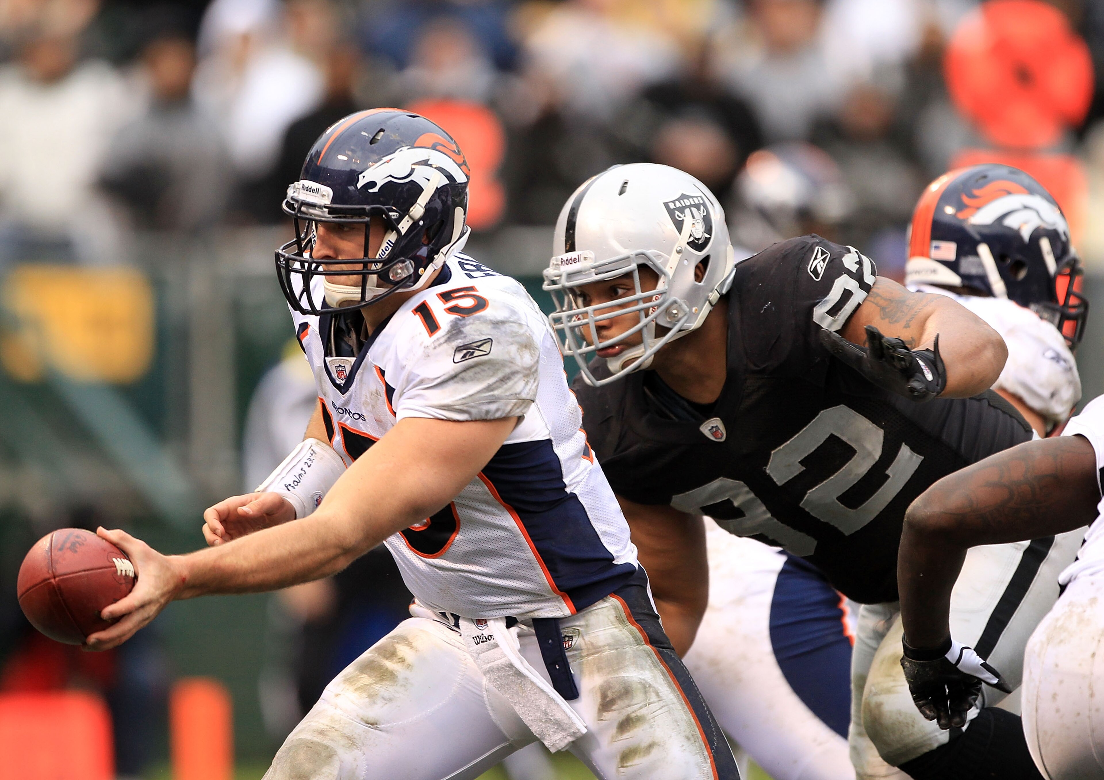 OAKLAND, CA - DECEMBER 19:  Tim Tebow #15 of the Denver Broncos hands off the ball before being hit by Richard Seymour #92 of the Oakland Raiders at Oakland-Alameda County Coliseum on December 19, 2010 in Oakland, California.  (Photo by Ezra Shaw/Getty Im