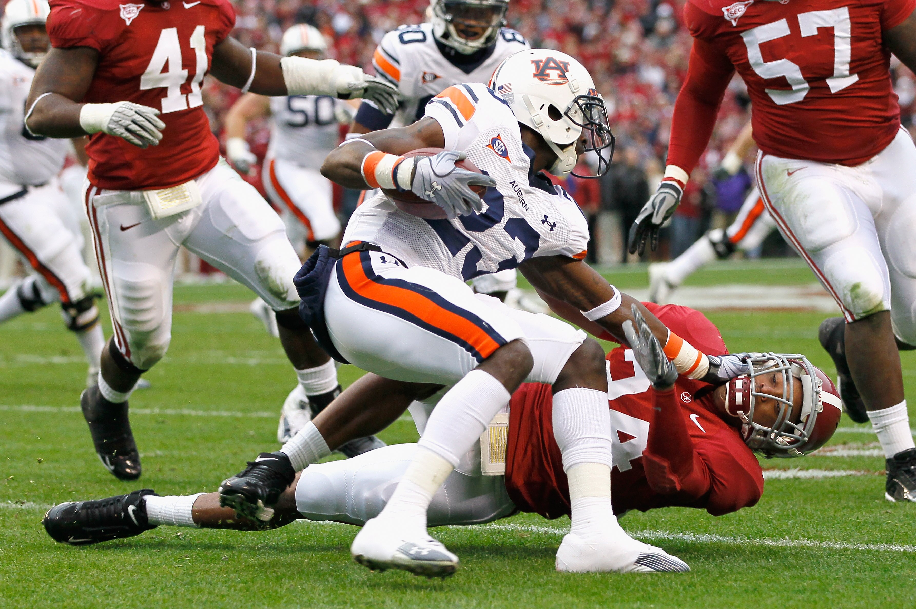TUSCALOOSA, AL - NOVEMBER 26:  Onterio McCalebb #23 of the Auburn Tigers is wrestled to the ground by DeQuan Menzie #24 of the Alabama Crimson Tide at Bryant-Denny Stadium on November 26, 2010 in Tuscaloosa, Alabama.  (Photo by Kevin C. Cox/Getty Images)