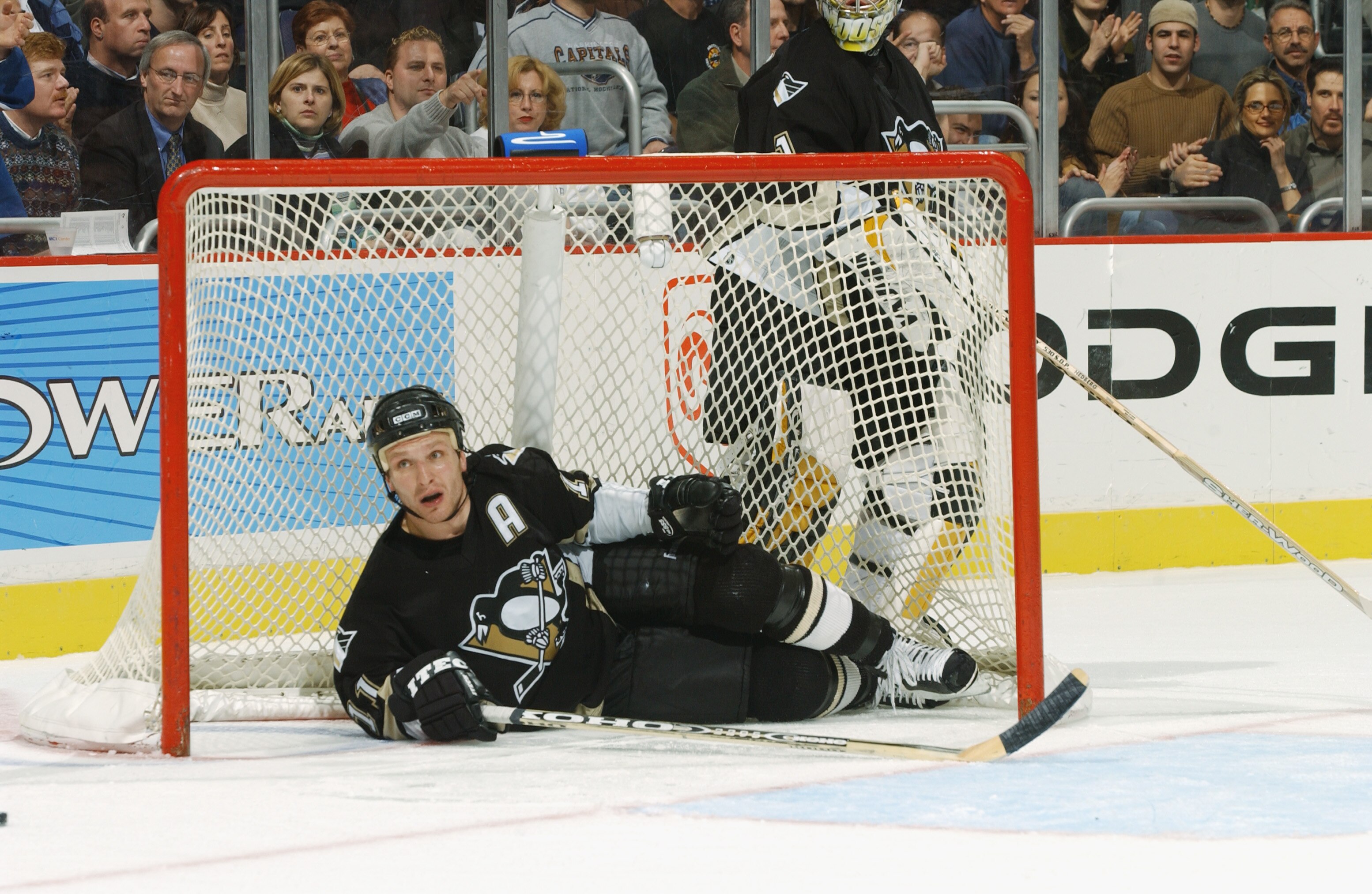 WASHINGTON - DECEMBER 11:  Defenseman Darius Kasparaitis #11 of the Pittsburgh Penguins ends up in his own goal after rough defensive play during the NHL game against the Washington Capitals at the MCI Center in Washington D.C. on December 11, 2001.  The