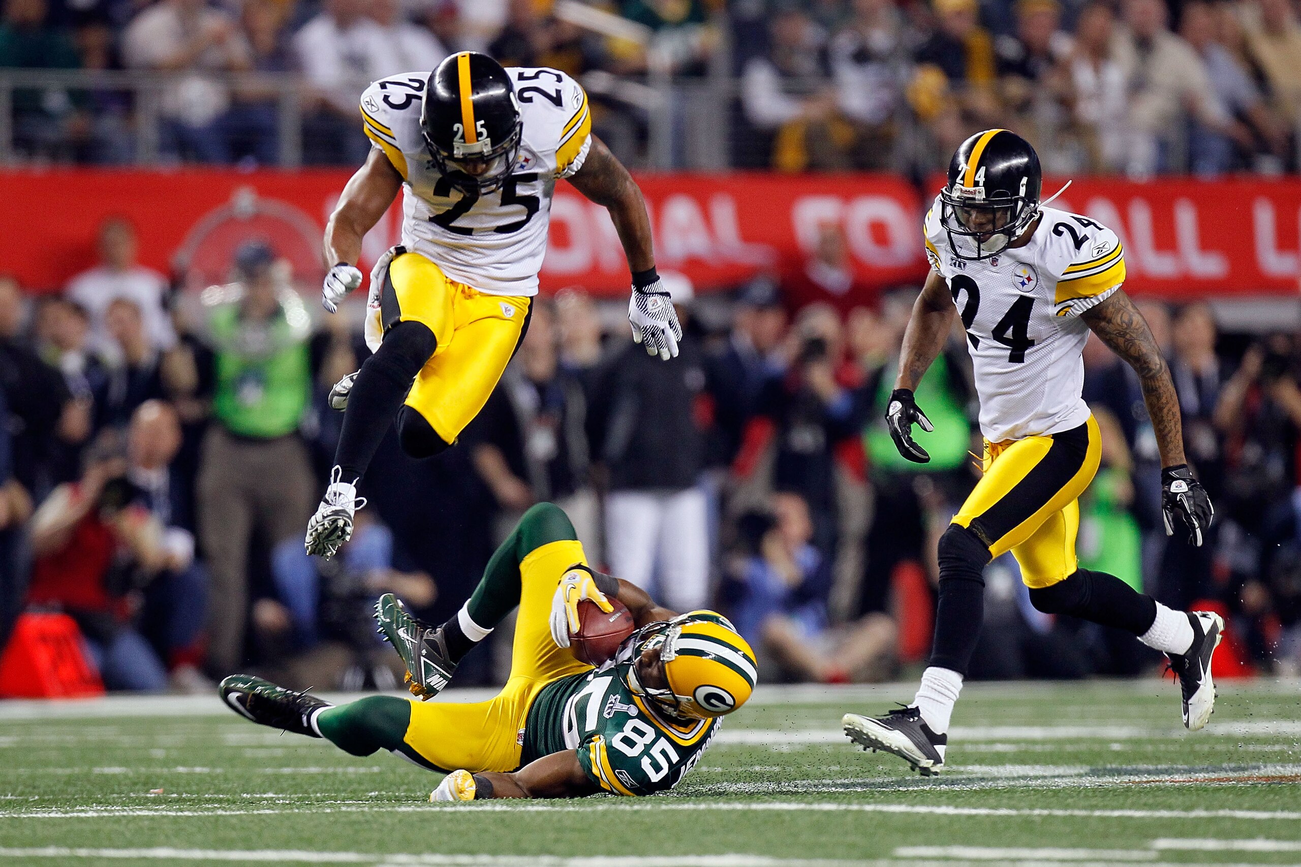 ARLINGTON, TX - FEBRUARY 06:  Greg Jennings #85 of the Green Bay Packers catches a 31 yard pass in the fourth quarter against Ryan Clark #25 and Ike Taylor #24 of the Pittsburgh Steelers during Super Bowl XLV at Cowboys Stadium on February 6, 2011 in Arli