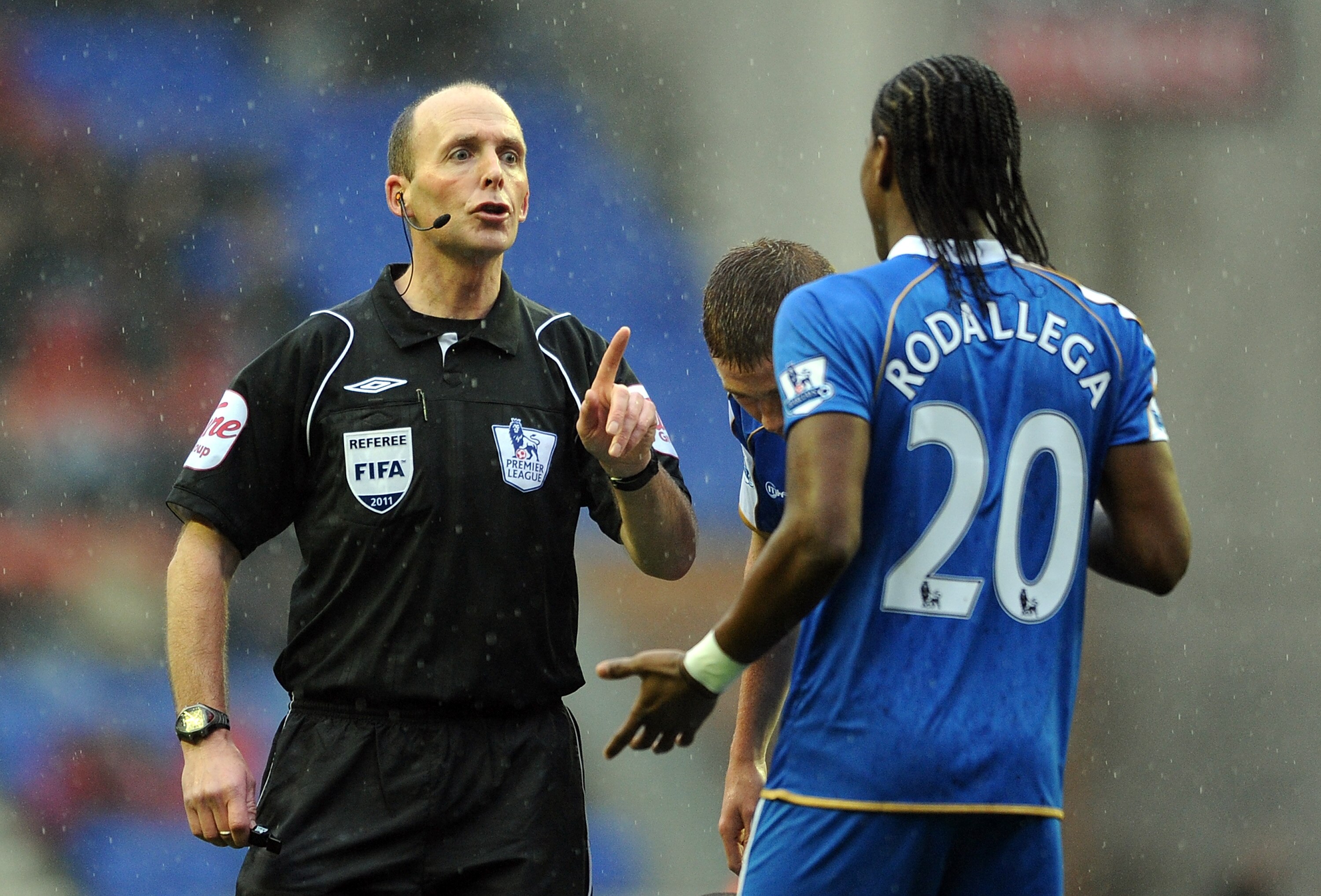 WIGAN, ENGLAND - FEBRUARY 05: Referee Mike Dean makes a point to Hugo Rodallega of Wigan Athletic during the Barclays Premier League match between Wigan Athletic and Blackburn Rovers at DW Stadium on February 5, 2011 in Wigan, England.  (Photo by Chris Br