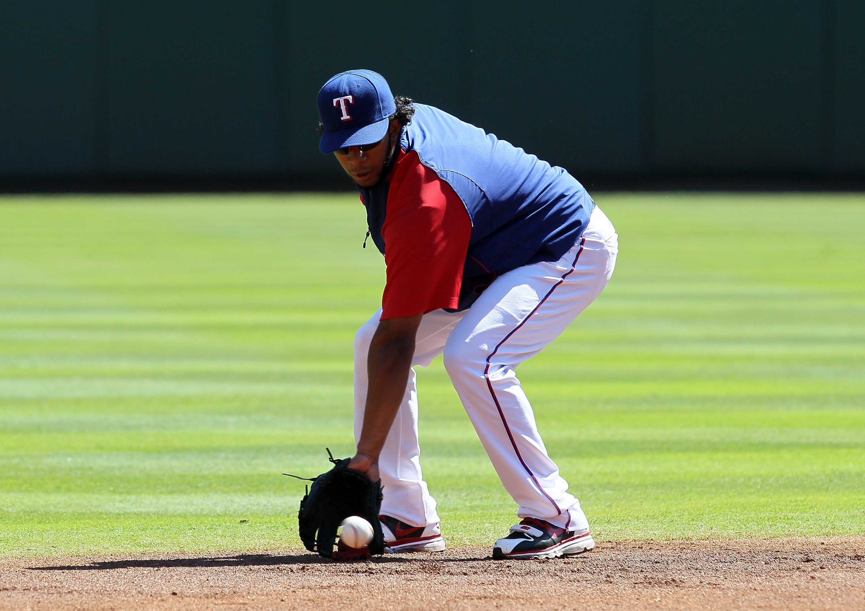 ARLINGTON, TX - OCTOBER 09:  Shortstop Elvis Andrus #1 of the Texas Rangers fields a grounder during batting practice before the game with the Tampa Bay Rays during game three of the ALDS at Rangers Ballpark in Arlington on October 9, 2010 in Arlington, T