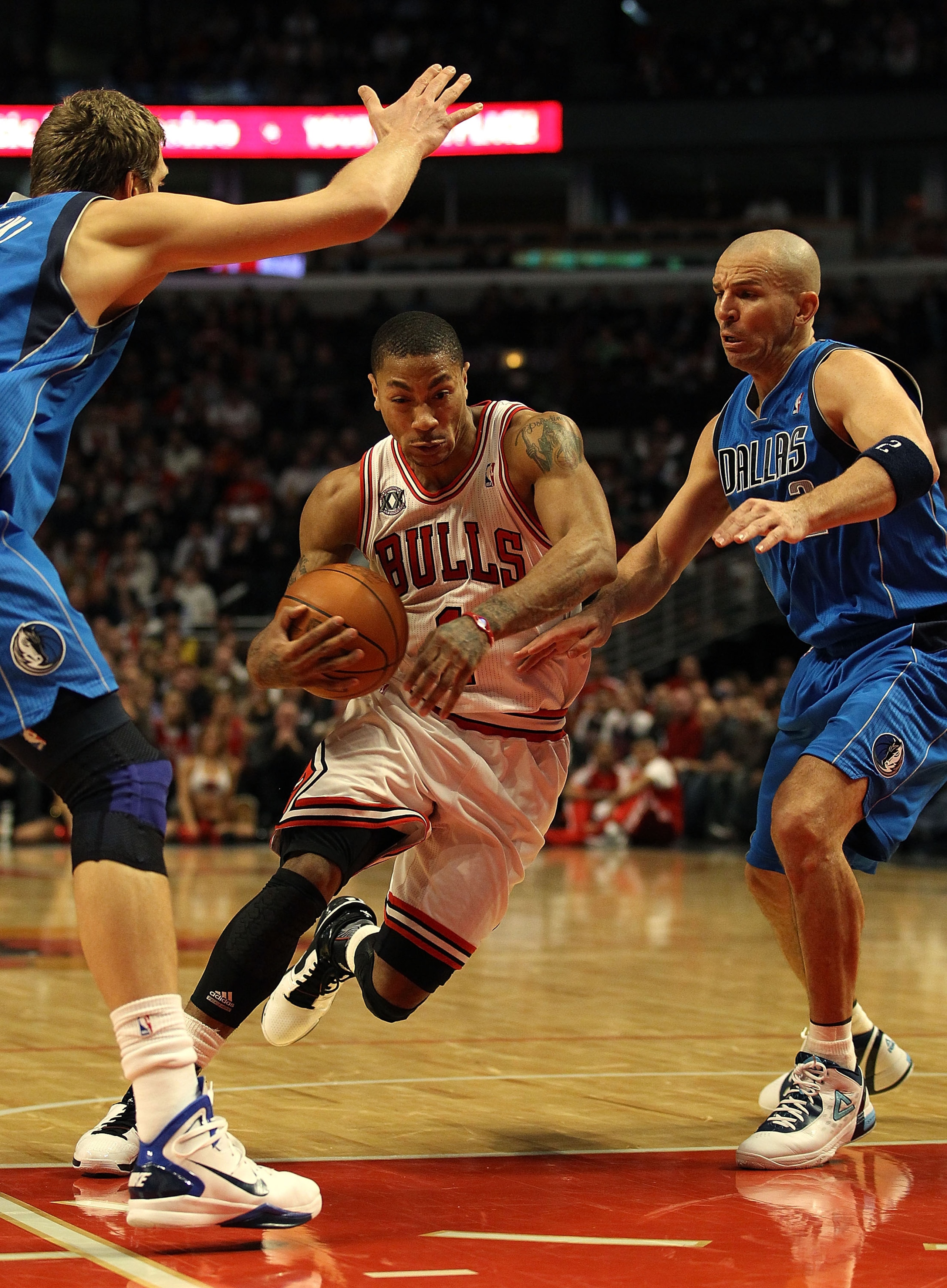CHICAGO, IL - JANUARY 20: Derrick Rose #1 of the Chicago Bulls drives between Jason Kidd #2 and Dirk Nowitzki #41 of the Dallas Mavericks at the United Center on January 20, 2011 in Chicago, Illinois. The Bulls defeated the Mavericks 82-77. NOTE TO USER: