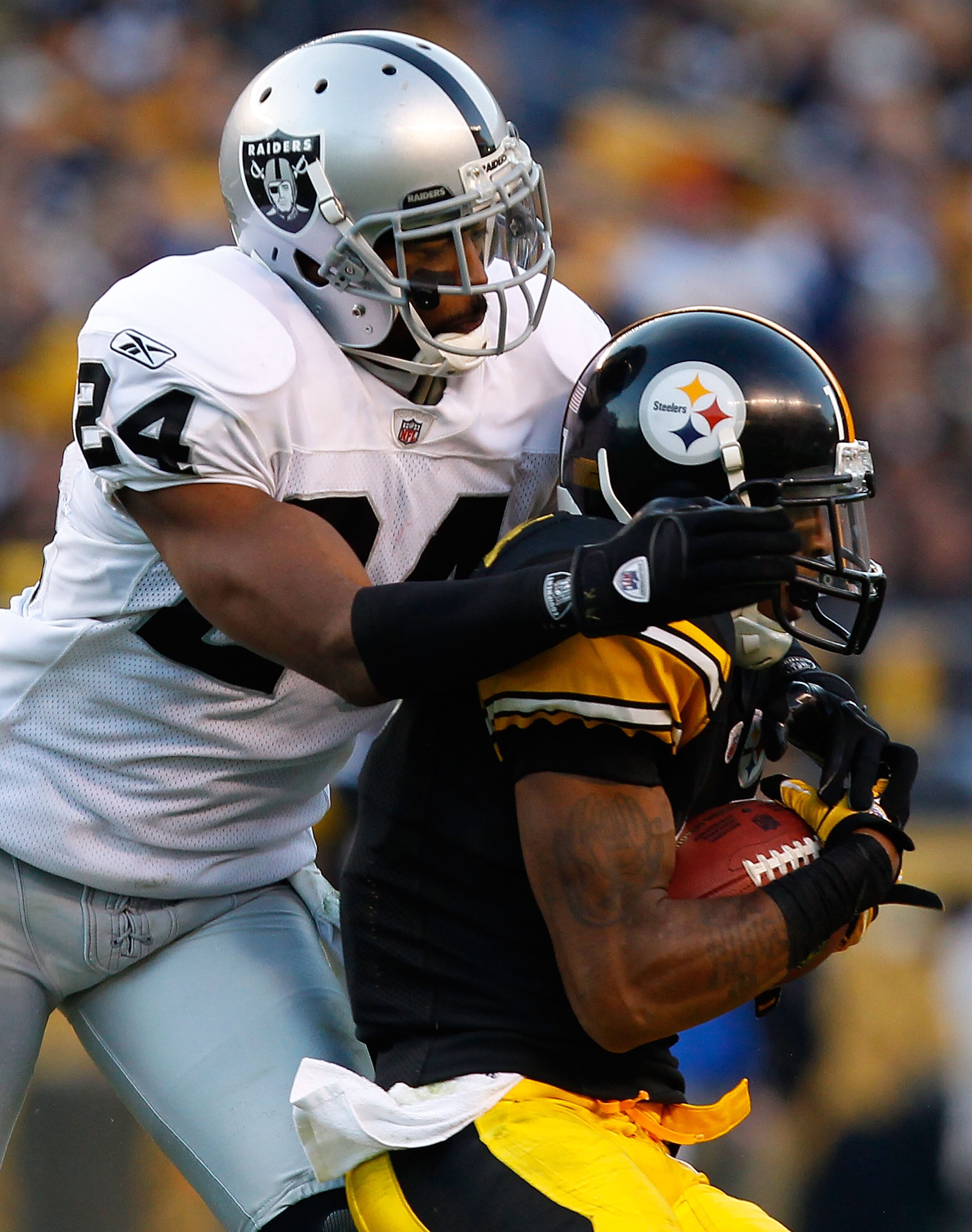 PITTSBURGH - NOVEMBER 21:  Mike Wallace #17 of the Pittsburgh Steelers makes a catch in front of Michael Huff #24 of the Oakland Raiders during the game on November 21, 2010 at Heinz Field in Pittsburgh, Pennsylvania.  (Photo by Jared Wickerham/Getty Imag