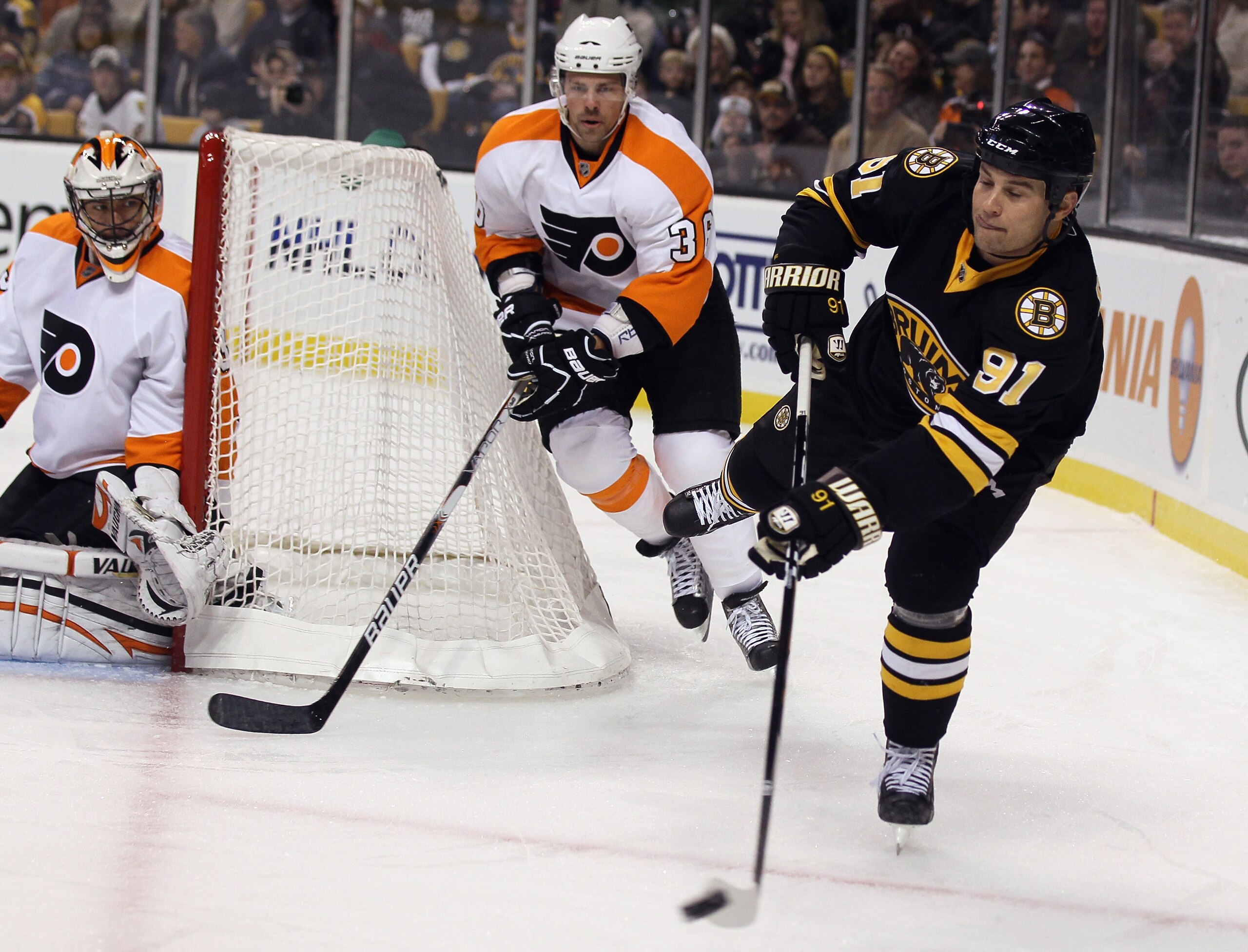 BOSTON, MA - DECEMBER 11: Marc Savard #91 of the Boston Bruins passes the puck as Brian Boucher #33 and Darroll Powe #36 of the Philadelphia Flyers defend on December 11, 2010 at the TD Garden in Boston, Massachusetts. (Photo by Elsa/Getty Images) BOSTON, MA - DECEMBER 11: Marc Savard #91 of the Boston Bruins passes the puck as Brian Boucher #33 and Darroll Powe #36 of the Philadelphia Flyers defend on December 11, 2010 at the TD Garden in Boston, Massachusetts. (Photo by Elsa/Getty Images)