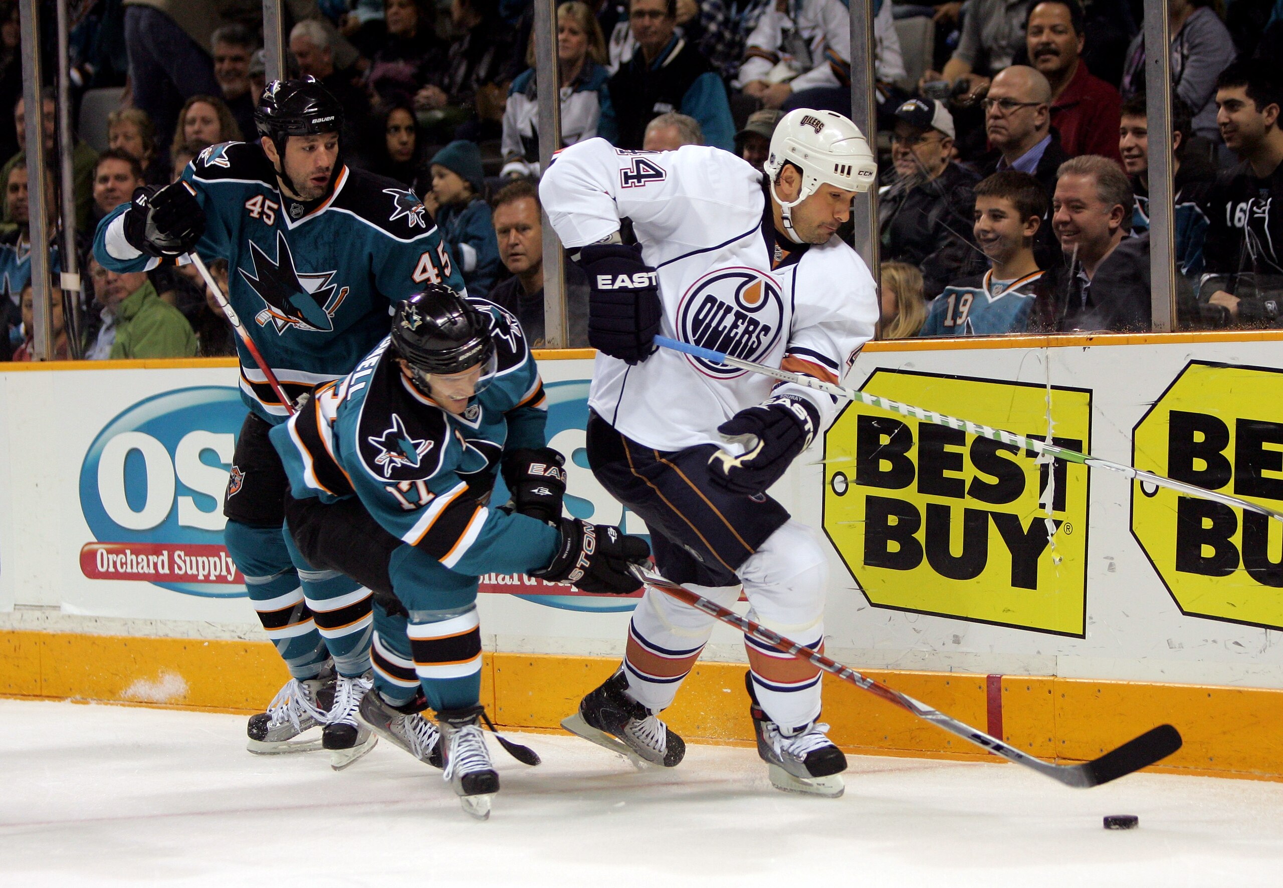 SAN JOSE, CA - JANUARY 16: Torrey Mitchell #17 and Jody Shelley #45 of the San Jose Sharks try to get the puck from Sheldon Souray #44 of the Edmonton Oilers during their game at HP Pavilion on January 16, 2010 in San Jose, California. (Photo by Ezra Sh SAN JOSE, CA - JANUARY 16: Torrey Mitchell #17 and Jody Shelley #45 of the San Jose Sharks try to get the puck from Sheldon Souray #44 of the Edmonton Oilers during their game at HP Pavilion on January 16, 2010 in San Jose, California. (Photo by Ezra Sh