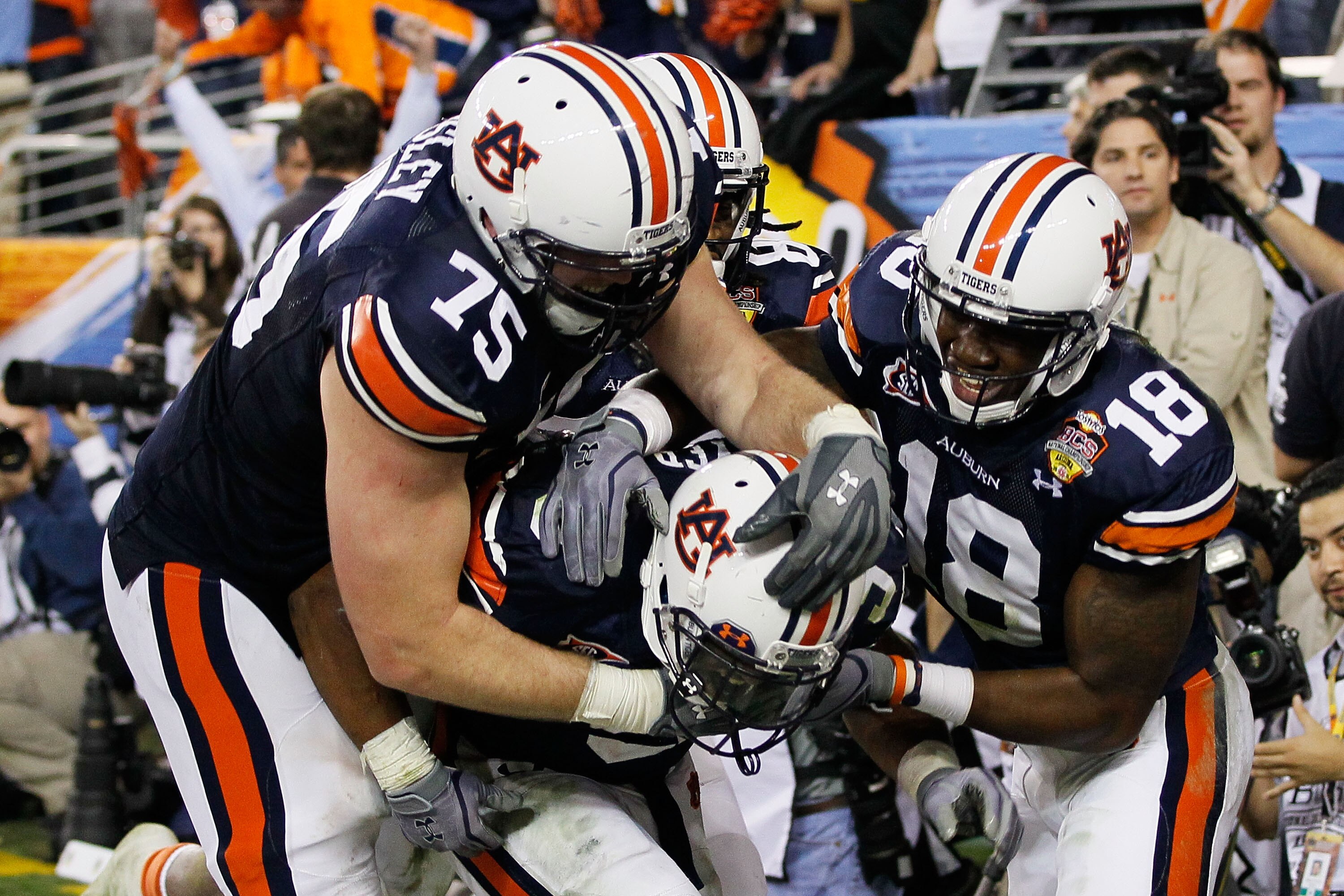 GLENDALE, AZ - JANUARY 10:  (C) Michael Dyer #5 of the Auburn Tigers celebrates with teammates Brandon Mosley #75 and Kodi Burns #18 after he ran the ball for 16-yards and is called down at the one-yardline with 10 seconds remaining in the fourth quarter