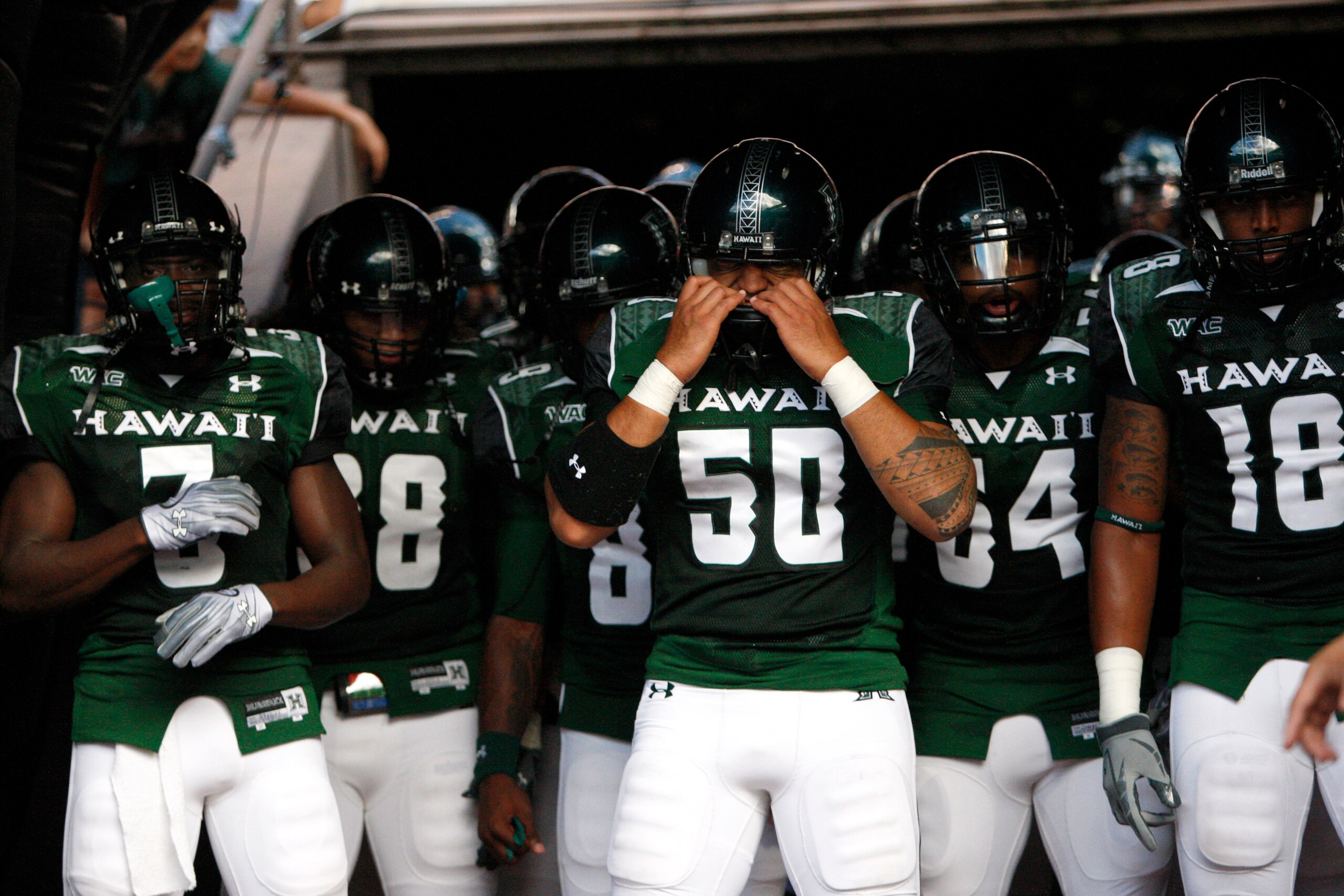 HONOLULU - SEPTEMBER 02: Mana Lolotai #50 of the University of Hawaii Warriors checks his helmet before the Warriors take the field in their season opener against the University of Southern California Trojans at Aloha Stadium September 2, 2010 in Honolulu HONOLULU - SEPTEMBER 02: Mana Lolotai #50 of the University of Hawaii Warriors checks his helmet before the Warriors take the field in their season opener against the University of Southern California Trojans at Aloha Stadium September 2, 2010 in Honolulu