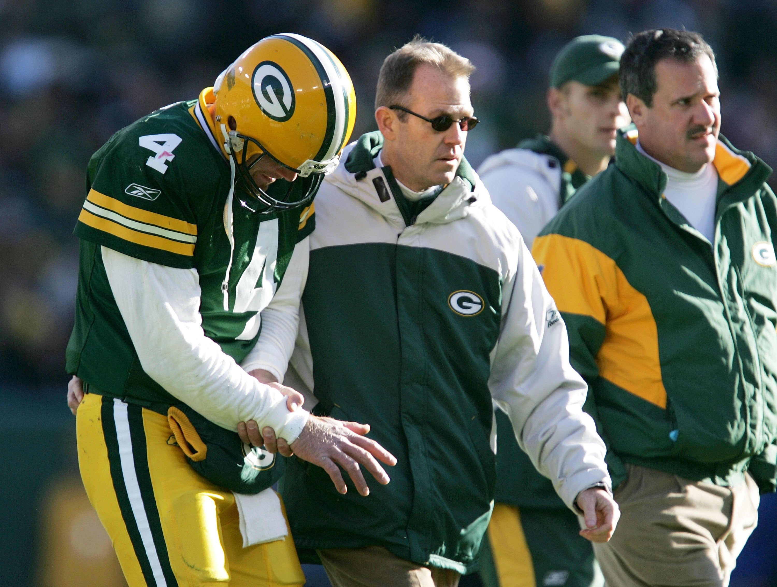 GREEN BAY, WI - NOVEMBER 19:  Brett Favre #4 of the Green Bay Packers is lead off the field by team doctors after injuring his arm on a sack by the New England Patriots on November 19, 2006 at Lambeau Field in Green Bay, Wisconsin.  (Photo by Jonathan Dan