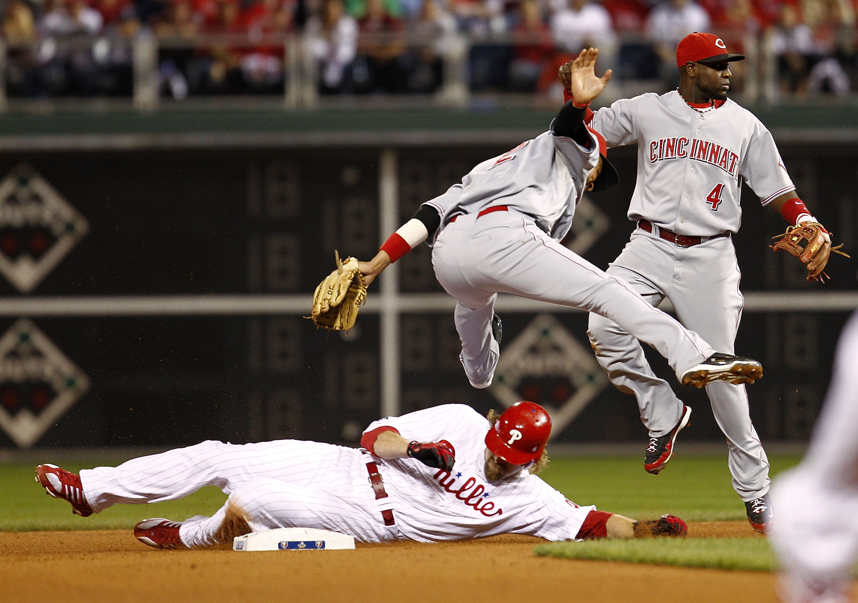 PHILADELPHIA - OCTOBER 08:  Jayson Werth #28 of the Philadelphia Phillies slides in as Orlando Cabrera #2 and Brandon Phillips #4 of the Cincinnati Reds jump clear in Game 2 of the NLDS at Citizens Bank Park on October 8, 2010 in Philadelphia, Pennsylvani