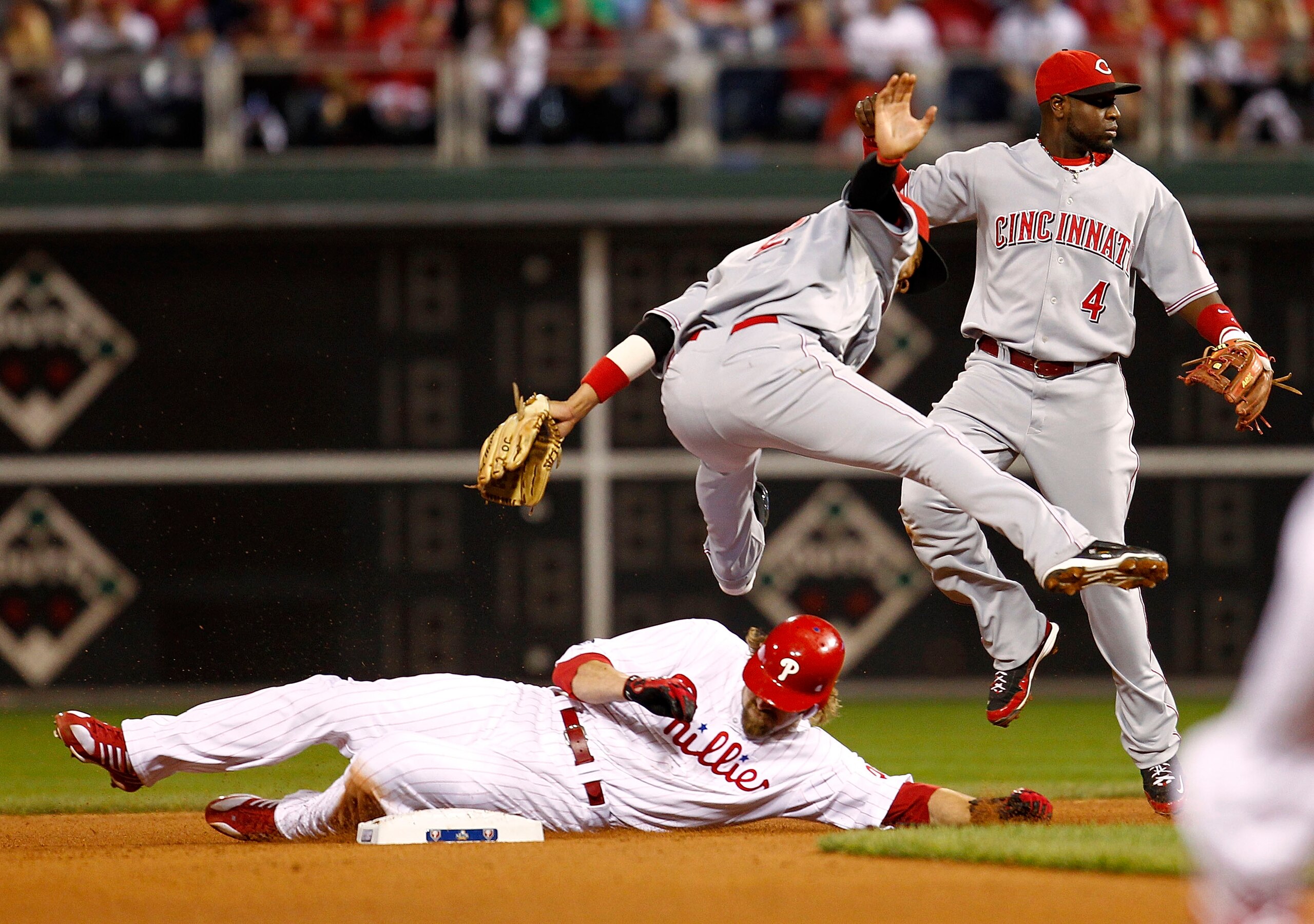 PHILADELPHIA - OCTOBER 08:  Jayson Werth #28 of the Philadelphia Phillies slides in as Orlando Cabrera #2 and Brandon Phillips #4 of the Cincinnati Reds jump clear in Game 2 of the NLDS at Citizens Bank Park on October 8, 2010 in Philadelphia, Pennsylvani