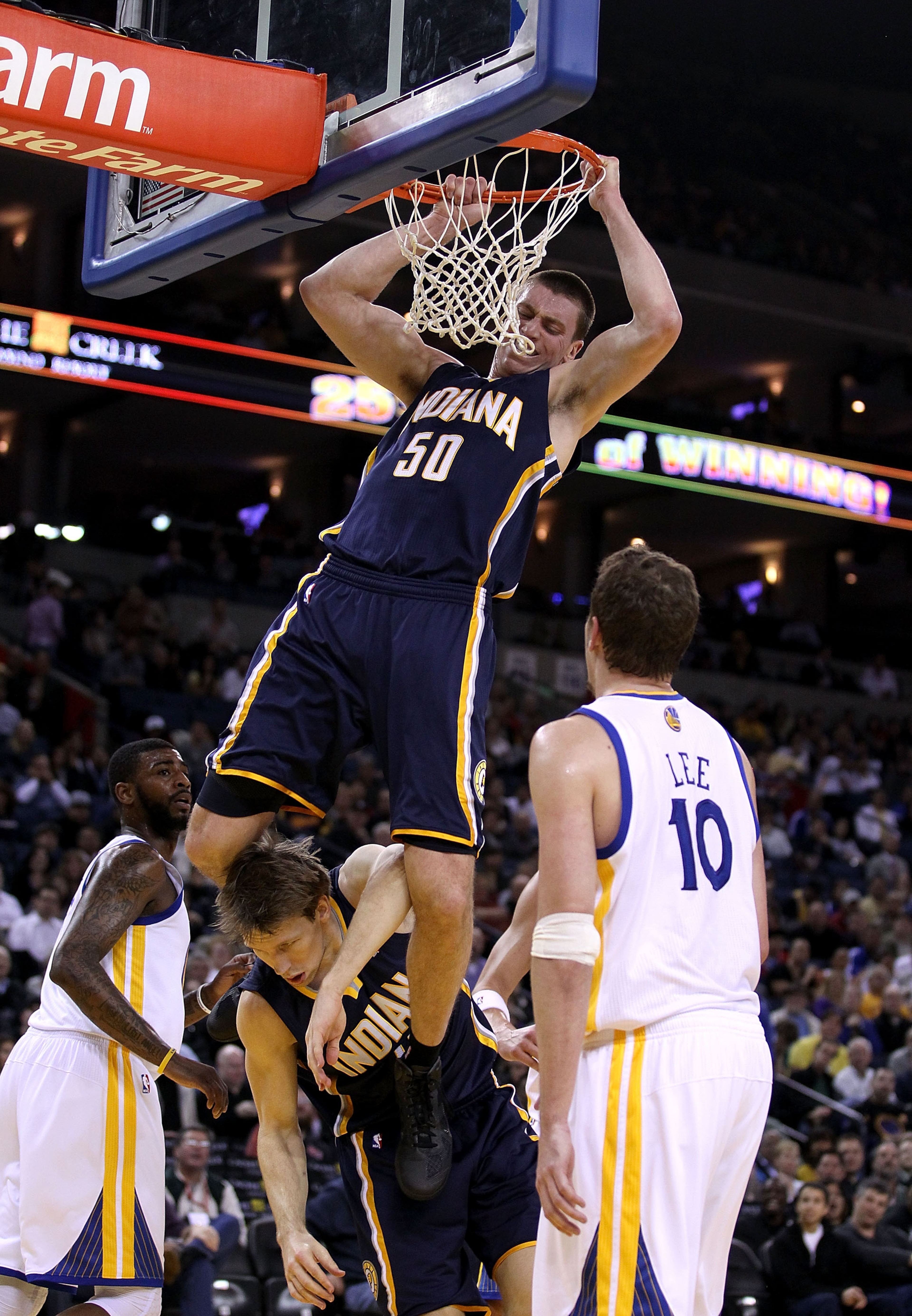 OAKLAND, CA - JANUARY 19:  Tyler Hansbrough #50 of the Indiana Pacers hangs on the rim after he dunked the ball so he doesn't land on Mike Dunleavy #17 during their game against the Golden State Warriors at Oracle Arena on January 19, 2011 in Oakland, Cal