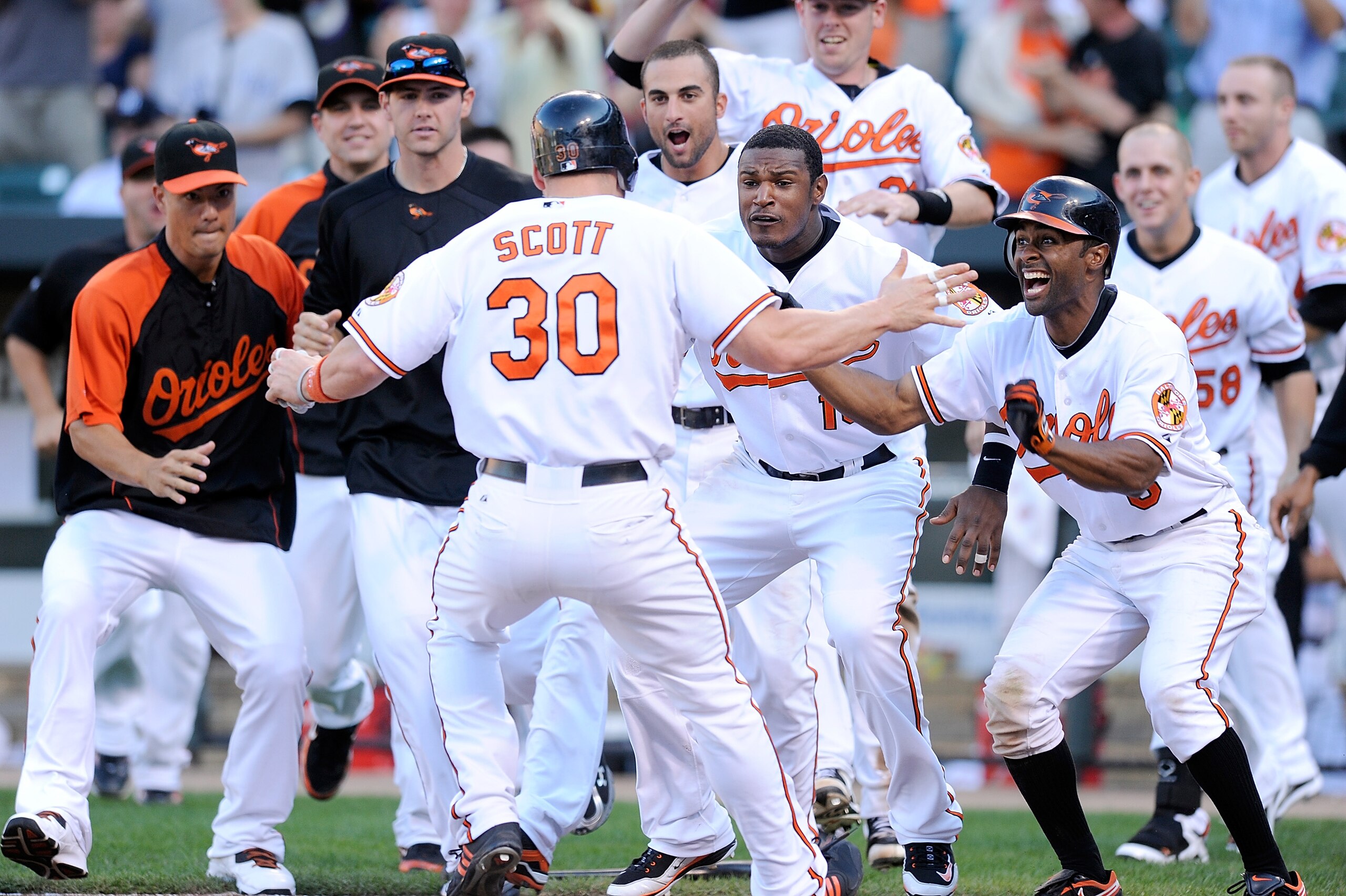 BALTIMORE - SEPTEMBER 19:  Luke Scott #30 of the Baltimore Orioles is congratulated by Adam Jones #10, Corey Patterson #6, Nick Markakis #21 and other teammates after scoring the game winning run in the eleventh inning against the New York Yankees at Camd