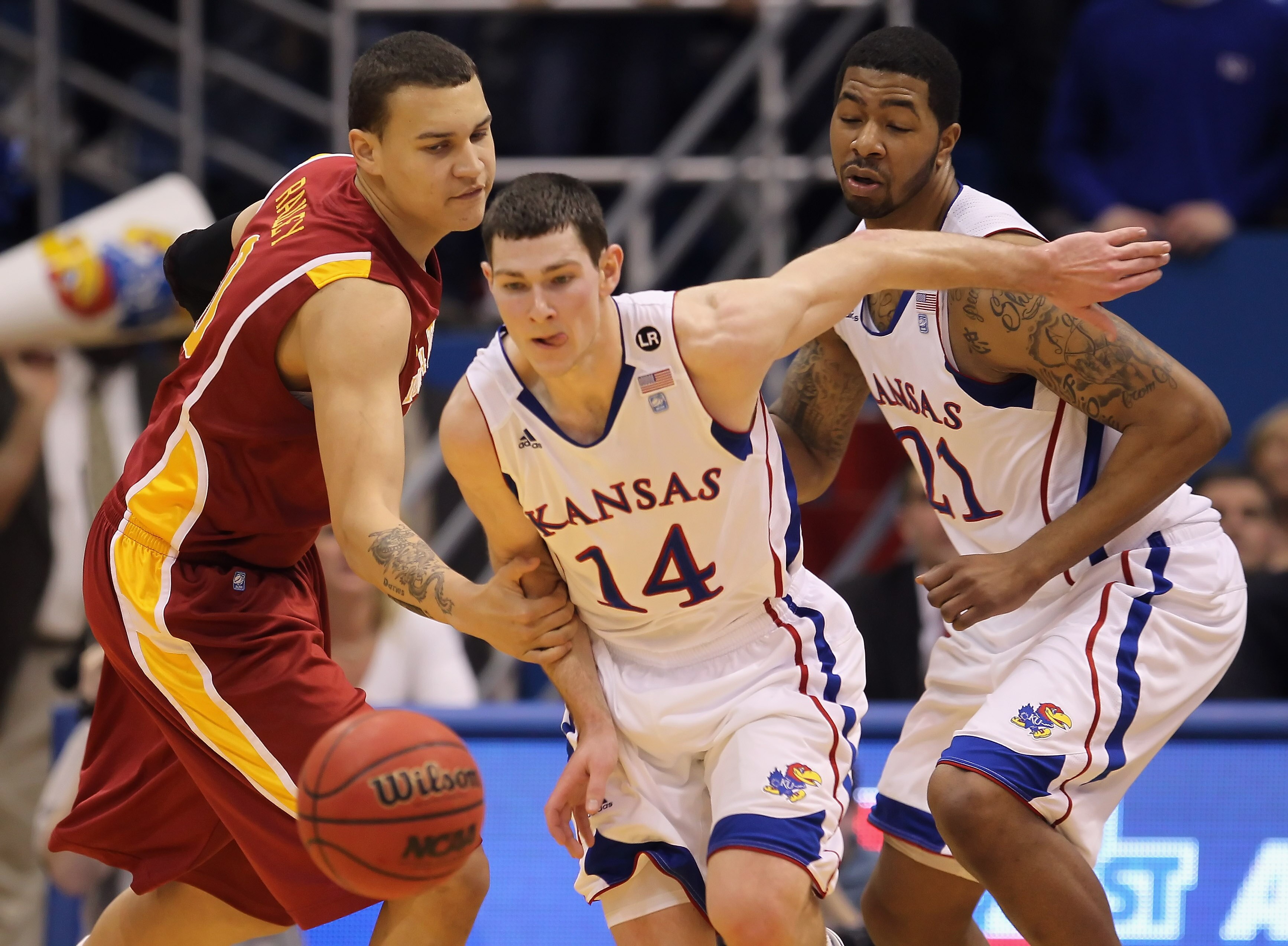 LAWRENCE, KS - FEBRUARY 12:  Jordan Railey #0 of the Iowa State Cyclones fouls Tyrel Reed #14 of the Kansas Jayhawks on a loose ball as Markieff Morris #21 looks on during the game on February 12, 2011 at Allen Fieldhouse in Lawrence, Kansas.  (Photo by J